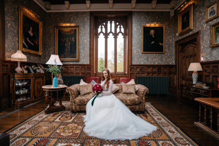 Bride sitting in the elegant bridal suite at Markree Castle, surrounded by antique decor and historic paintings – perfect for luxury Irish castle weddings.