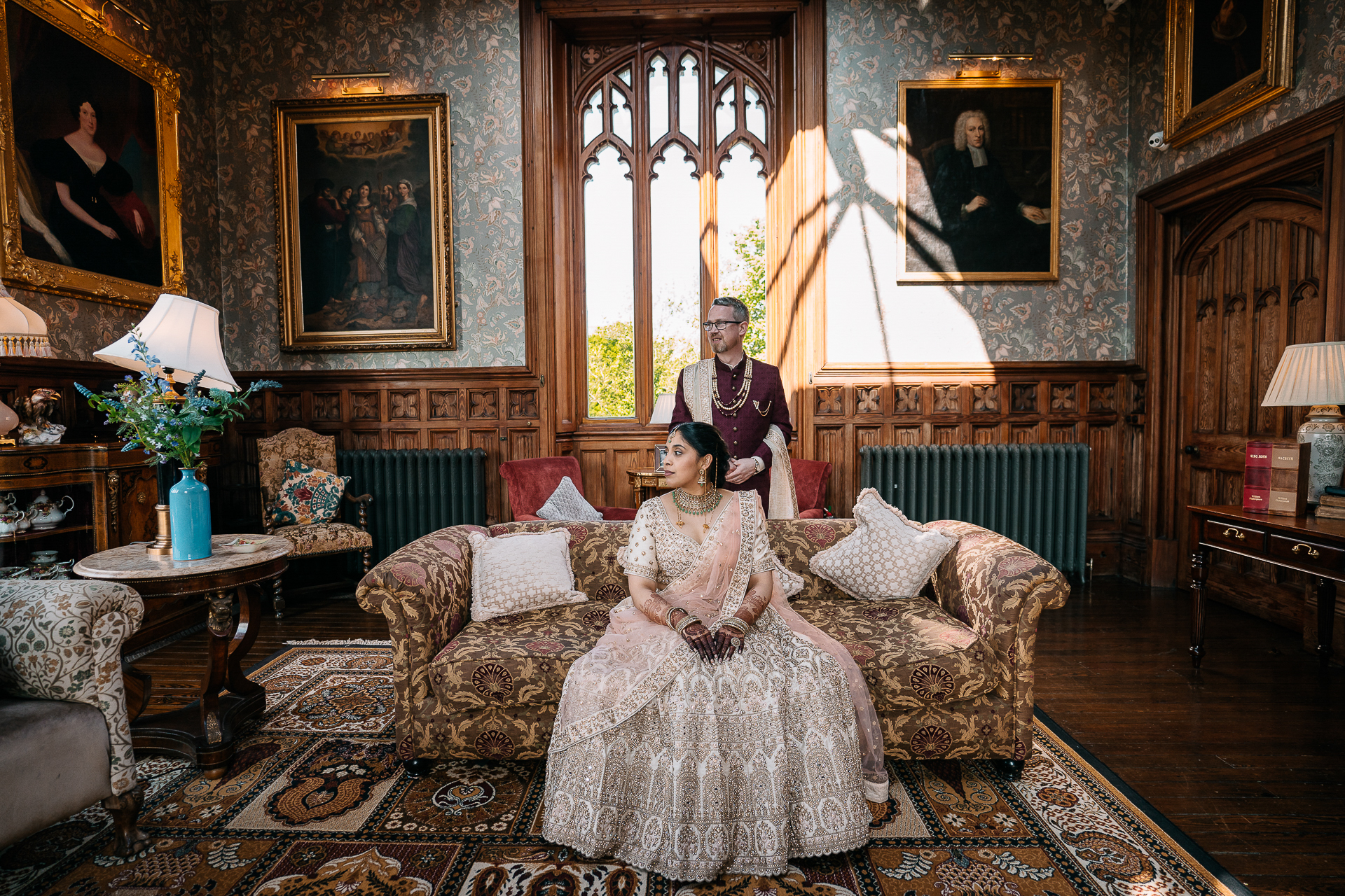 Indian bride sitting on a sofa in the historic drawing room of Markree Castle during wedding portrait session