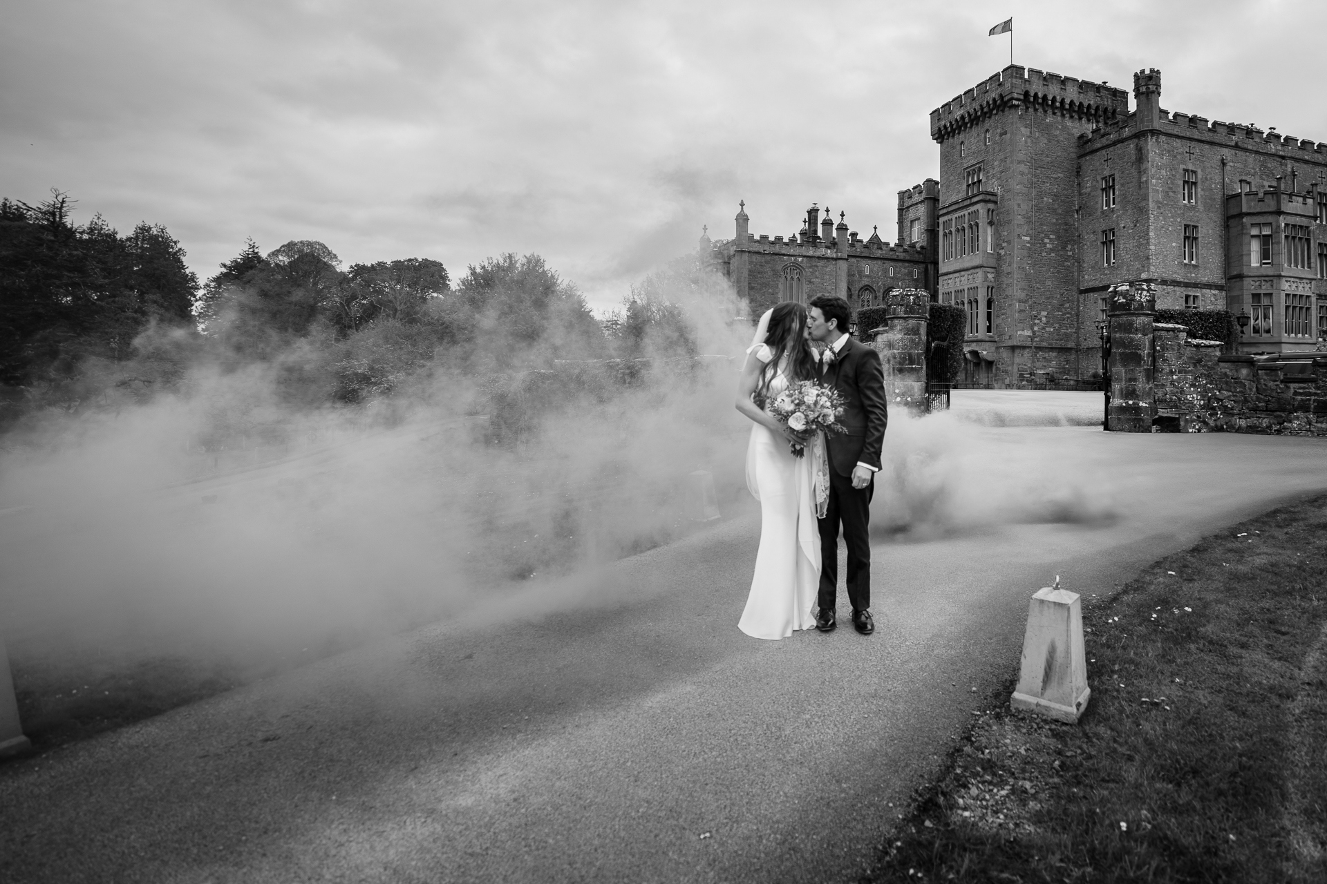 Bride and groom surrounded by smoke in a dramatic black and white wedding portrait outside Markree Castle.