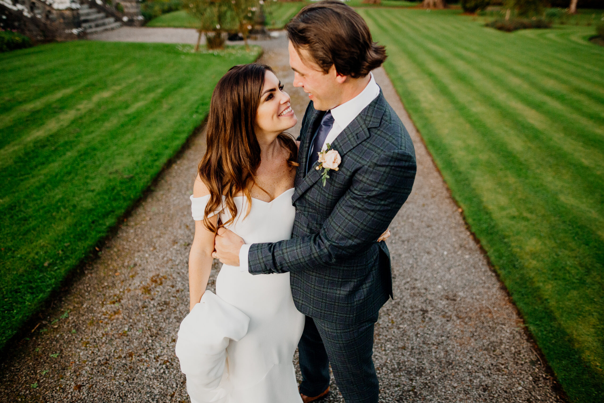 Bride and groom smiling and embracing on the garden path at Markree Castle – elegant wedding portrait in vibrant colour
