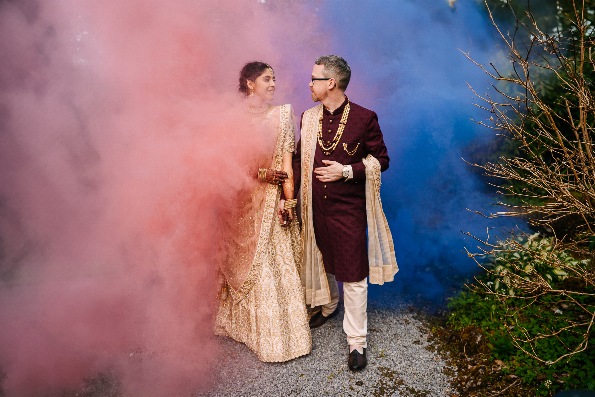 Indian bride and groom walking through colourful smoke at Markree Castle wedding