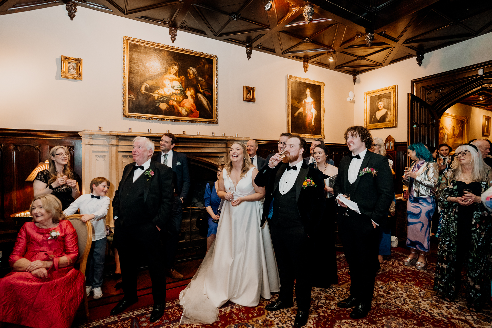 Bride and groom surrounded by family and friends during evening wedding reception toast at Markree Castle