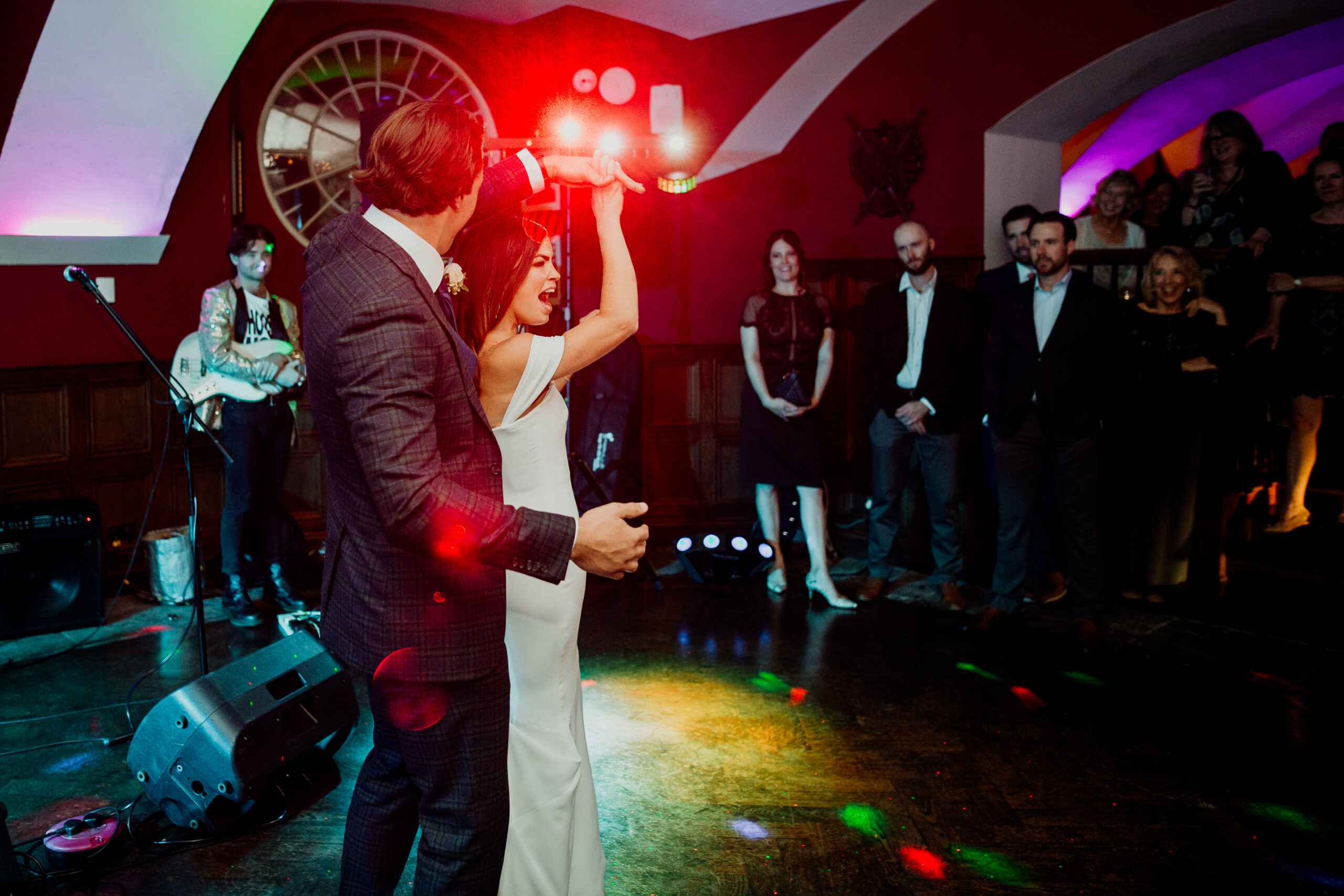 First dance during wedding at Markree Castle – couple dancing with live band and colorful lighting