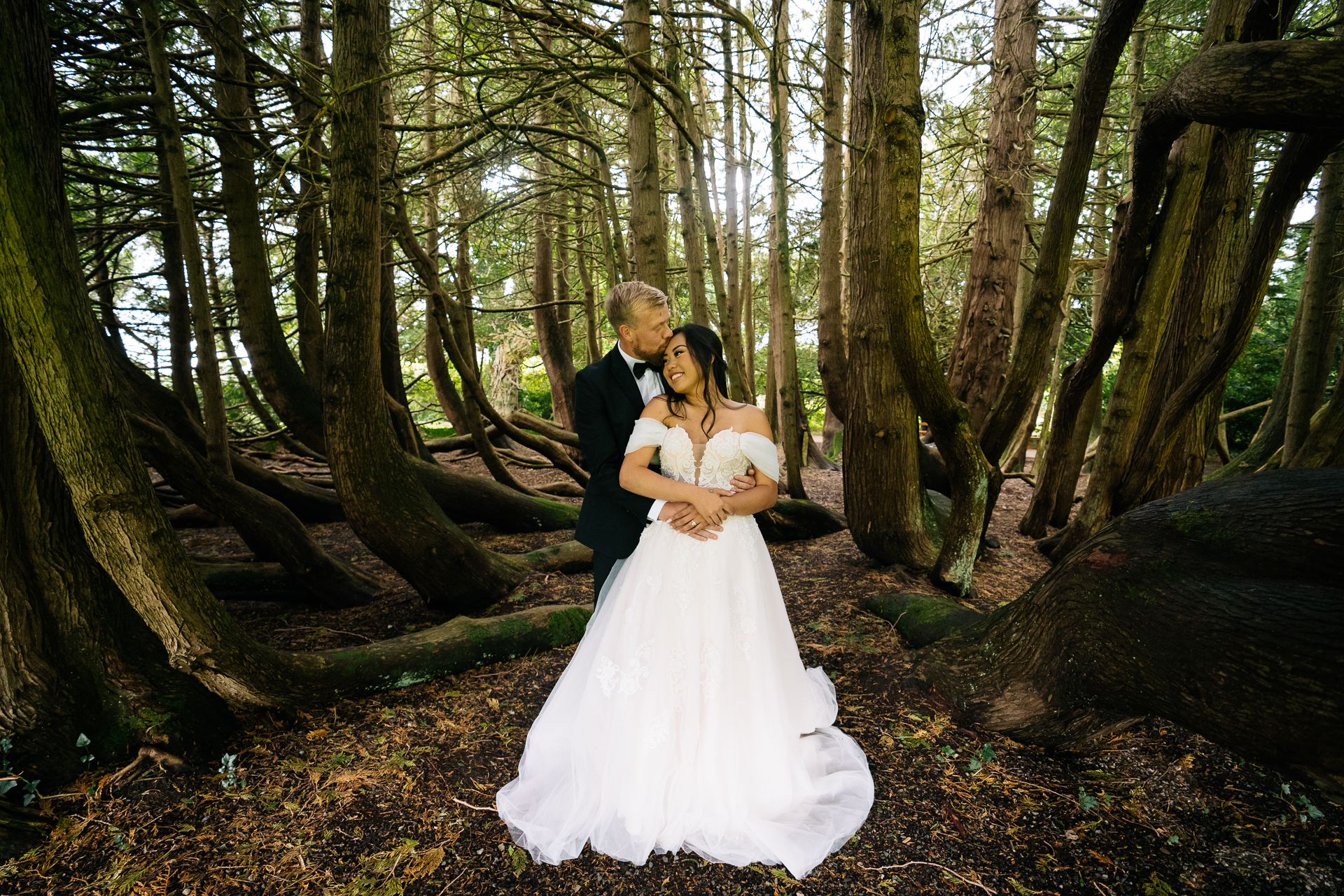 Bride and groom pose in the forest at Markree Castle surrounded by tall trees and natural light