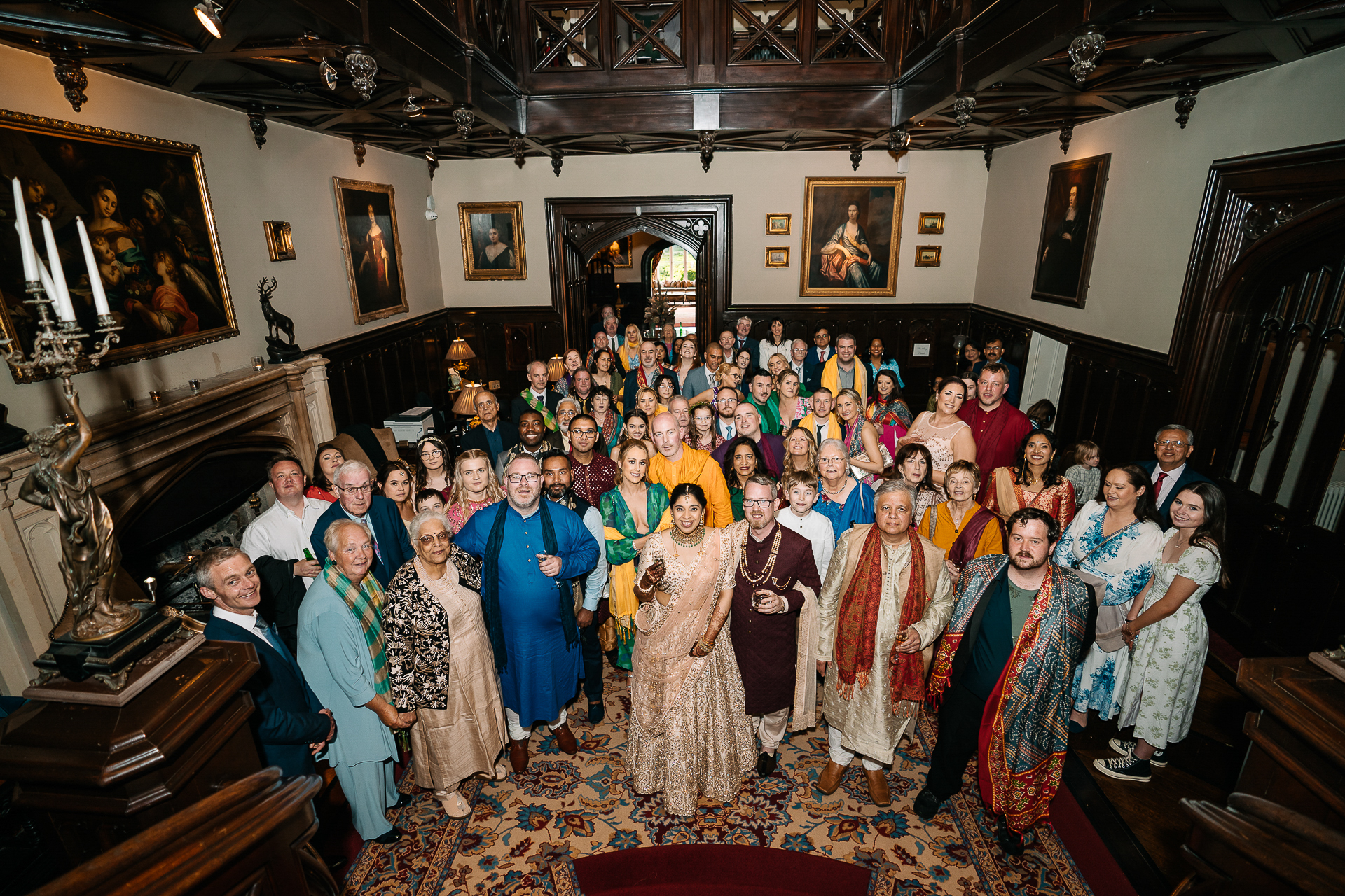 Wedding guests gathered for a formal group portrait inside Markree Castle during a colourful Indian wedding