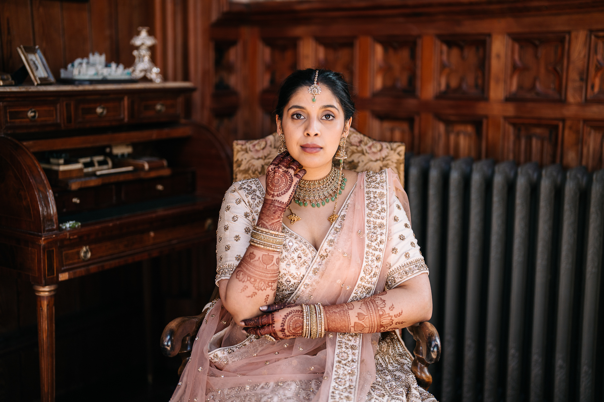 Indian bride sitting beside a vintage piano at Markree Castle before her wedding ceremony