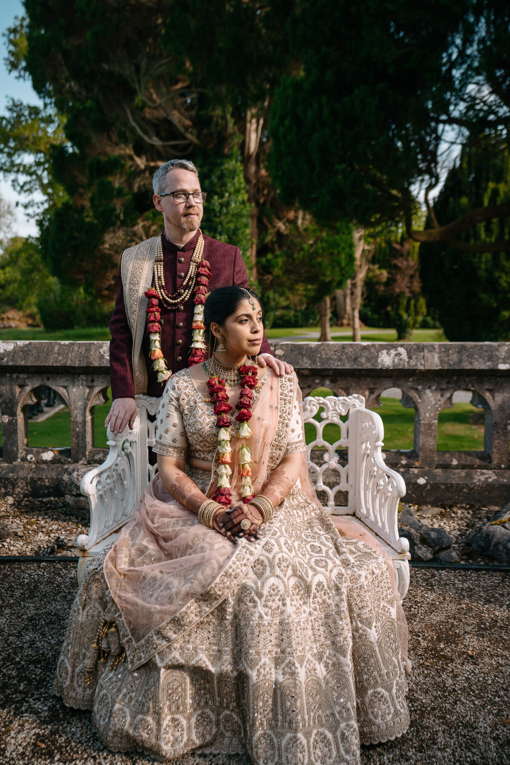 Indian bride and groom seated in the romantic garden of Markree Castle during their wedding day