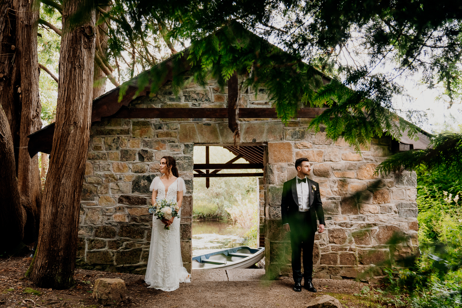 Bride and groom standing separately in front of a rustic stone archway at Markree Castle during their wedding day.