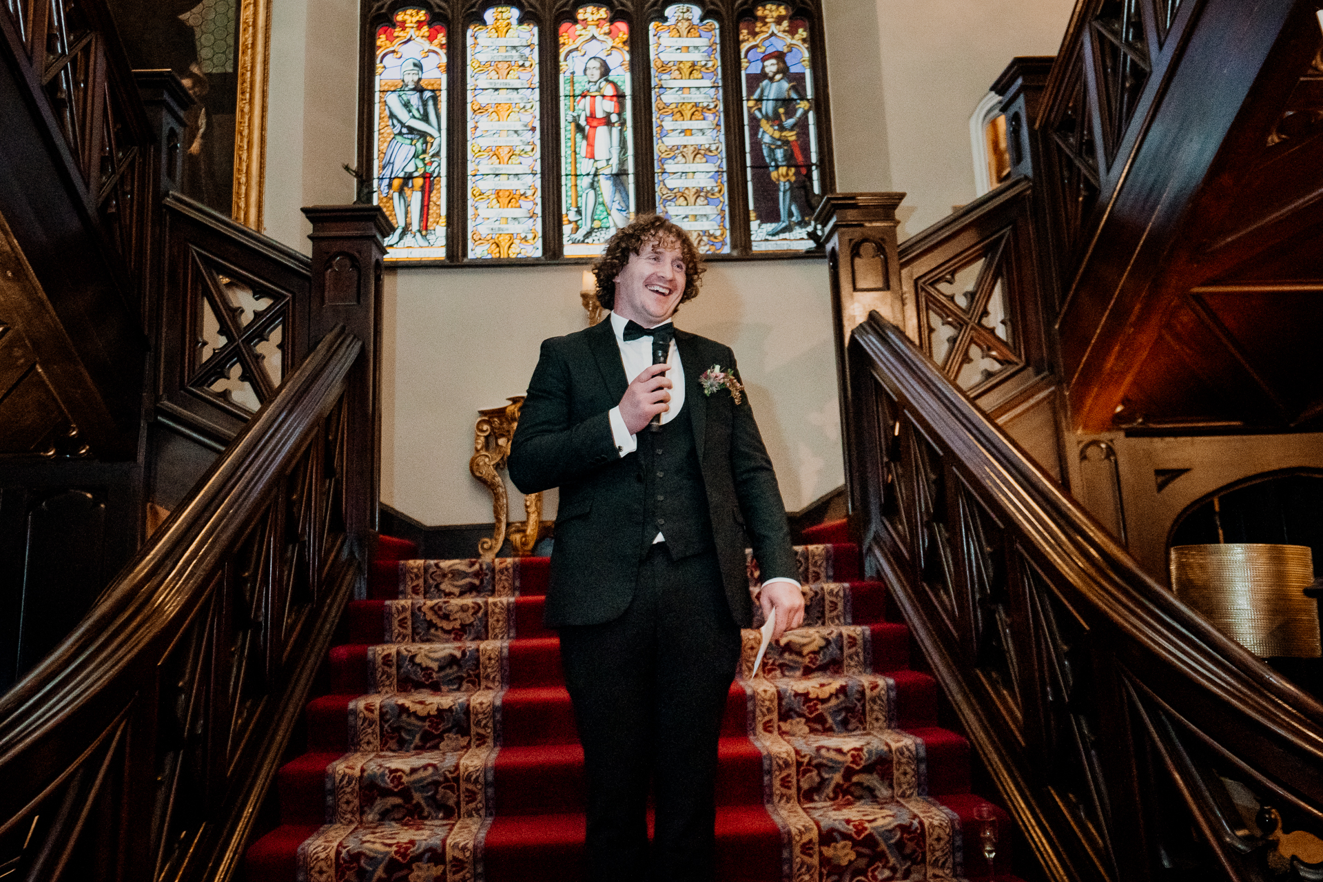 Groomsman giving a joyful wedding speech on the grand staircase at Markree Castle