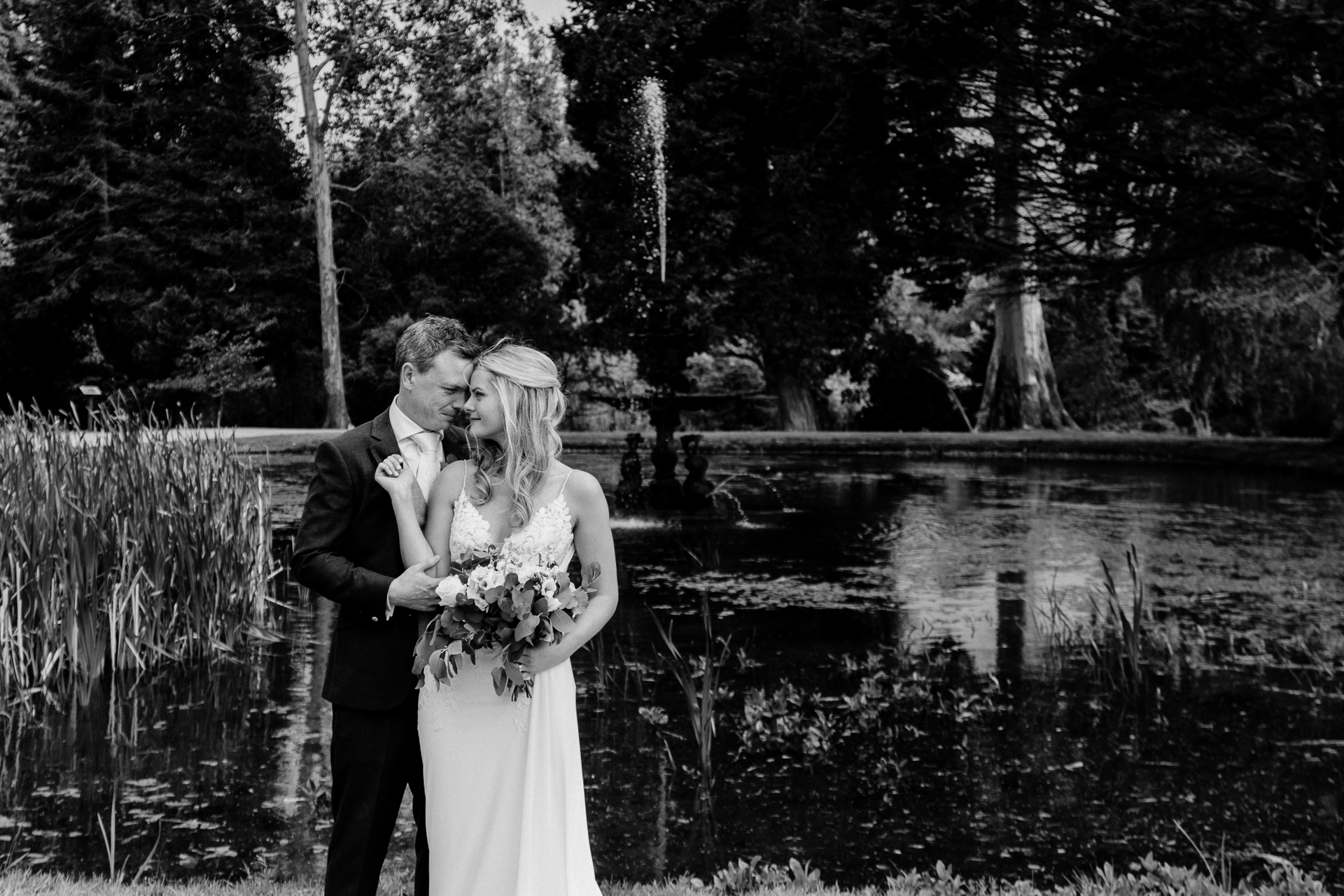 Romantic black and white wedding portrait by the pond at Powerscourt House, captured by a Dublin Wedding Photographer during a beautiful outdoor moment