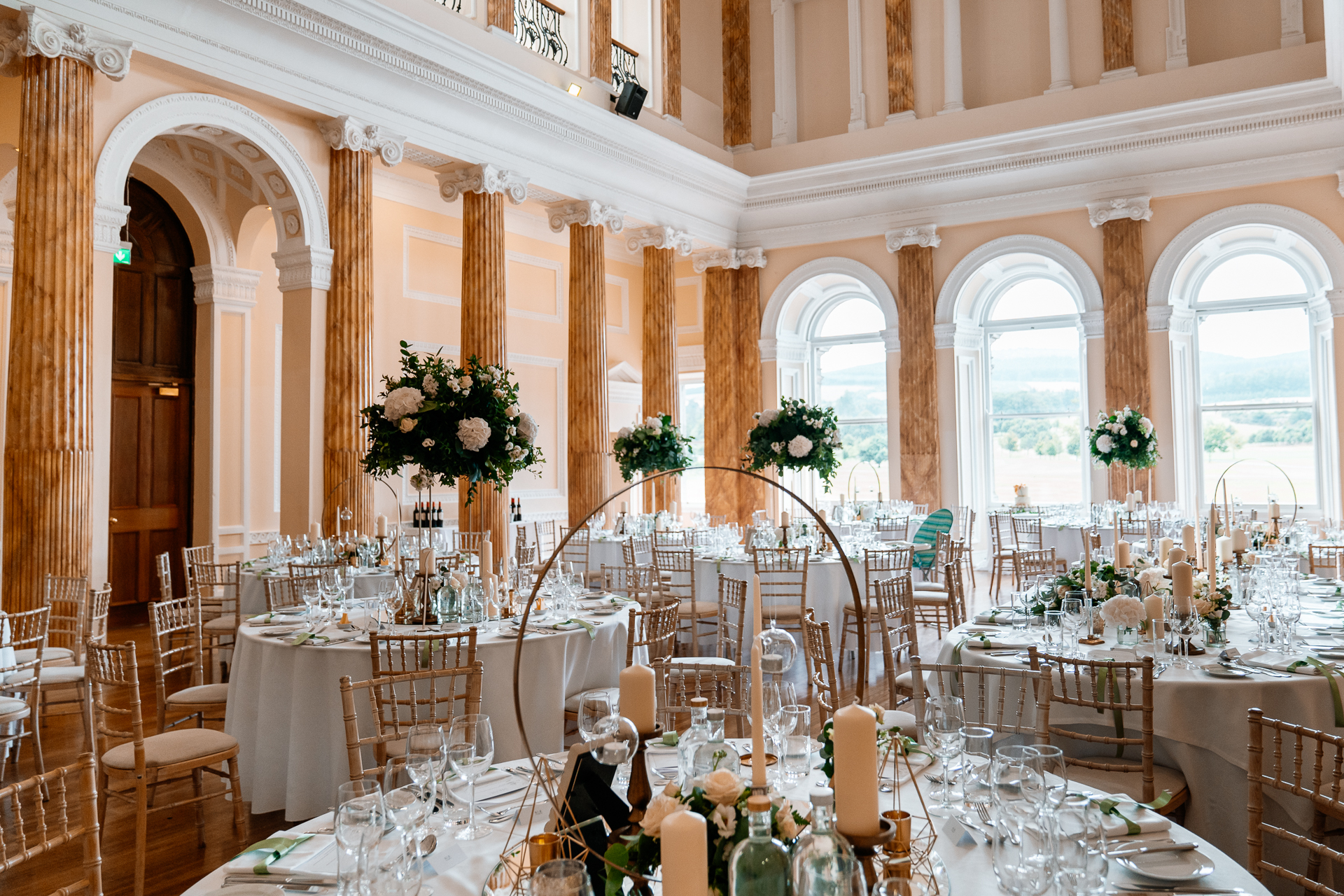 Elegant wedding reception room setup with floral centerpieces at Powerscourt House, captured by a Dublin Wedding Photographer
