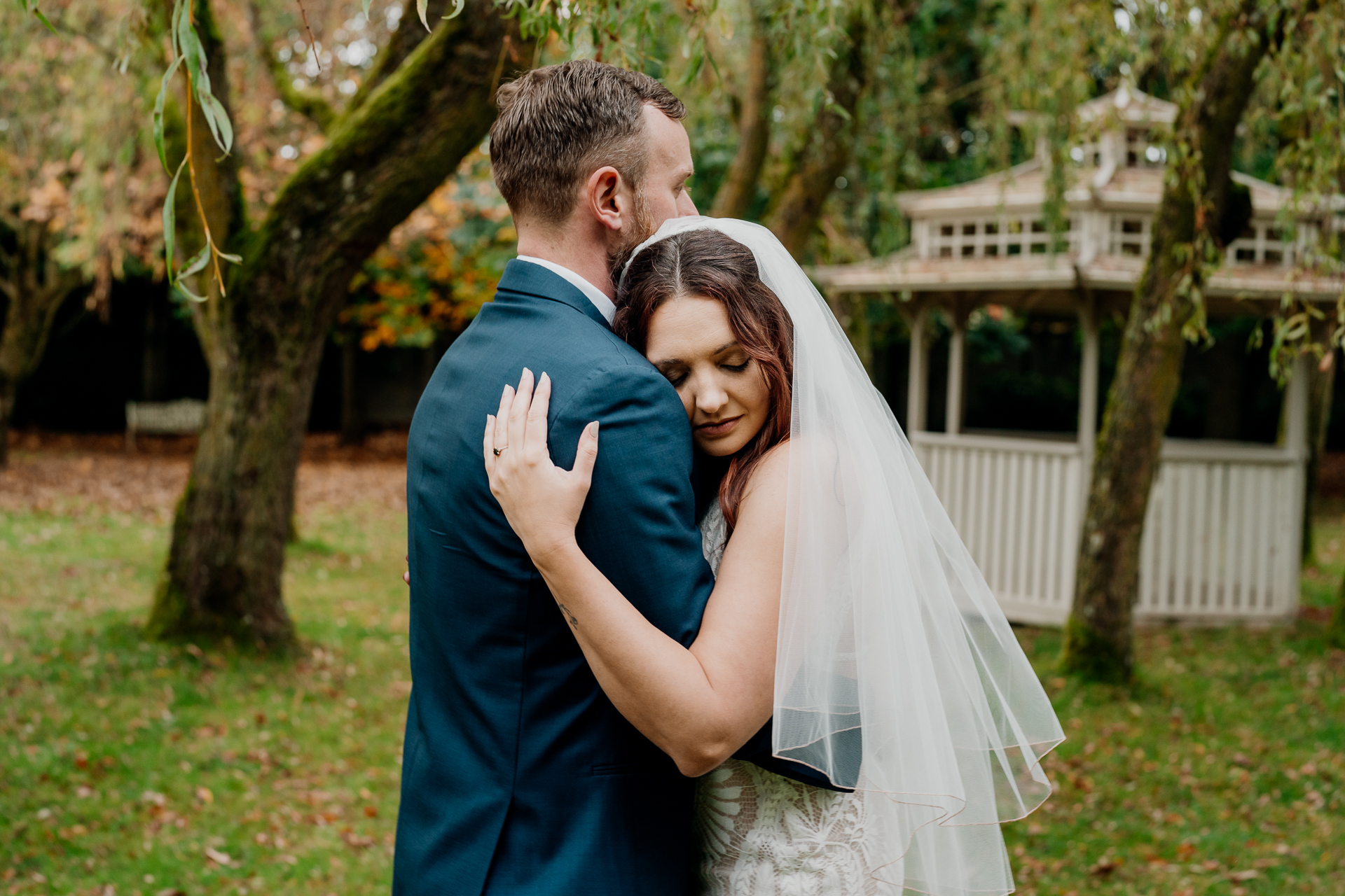 Bride embracing the groom in a quiet moment at Barberstown Castle garden, captured by a Dublin Wedding Photographer.