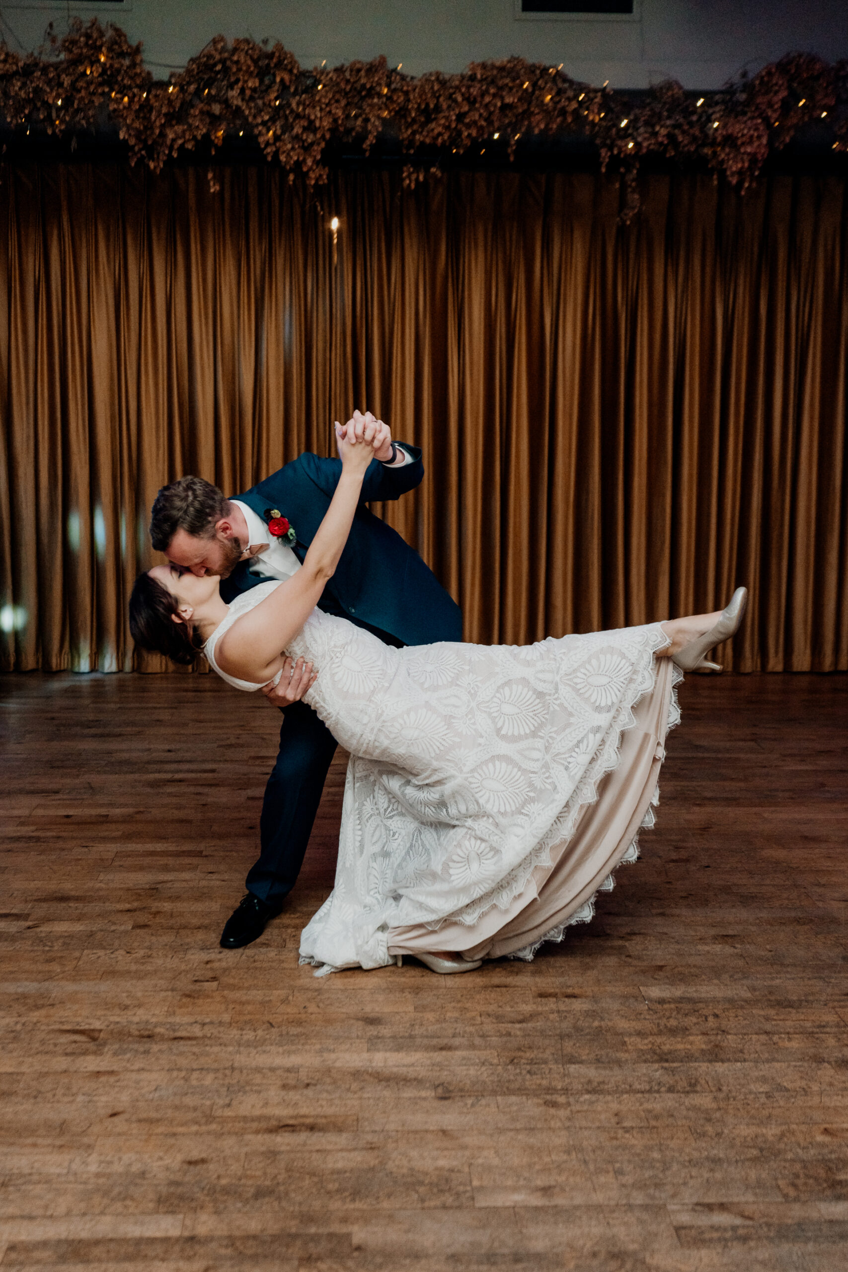 Bride and groom performing a dip on the dance floor at Barberstown Castle, surrounded by warm lights and rustic decor.