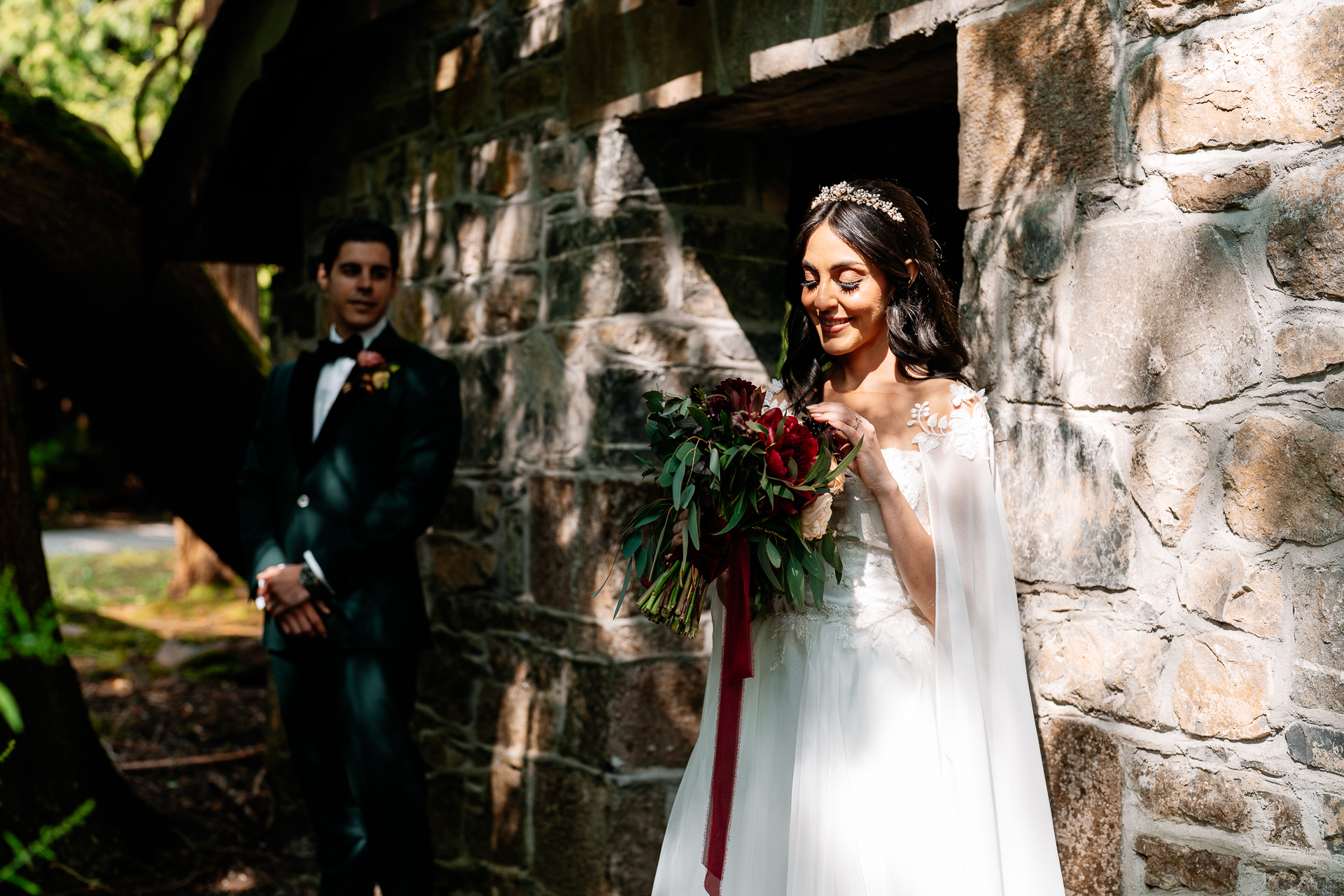 Bride and groom standing beside a rustic stone wall at Markree Castle’s Boathouse during their wedding portrait session


