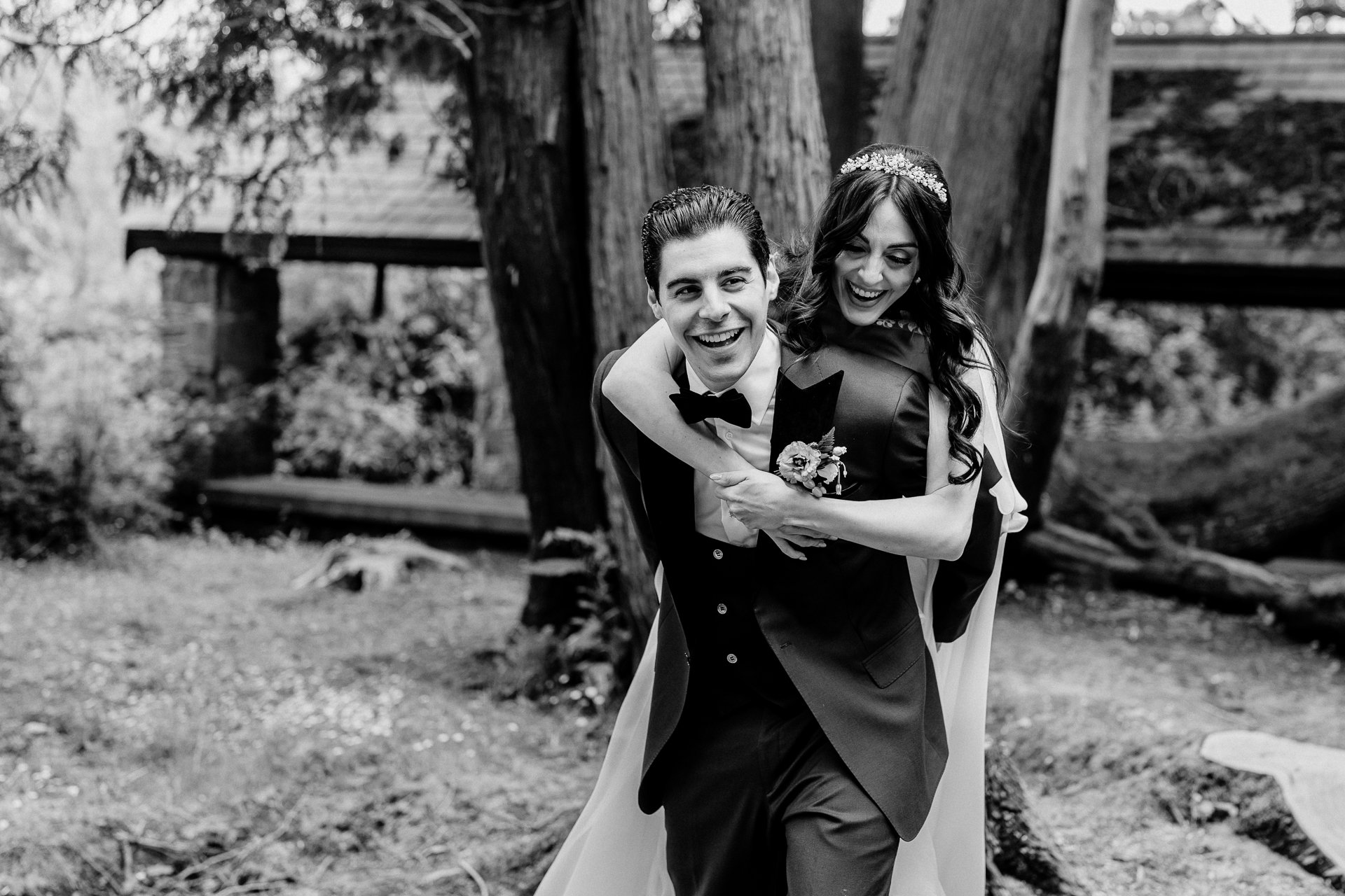 Playful black and white photo of a bride and groom in the forest near the Boathouse at Markree Castle during their wedding day

