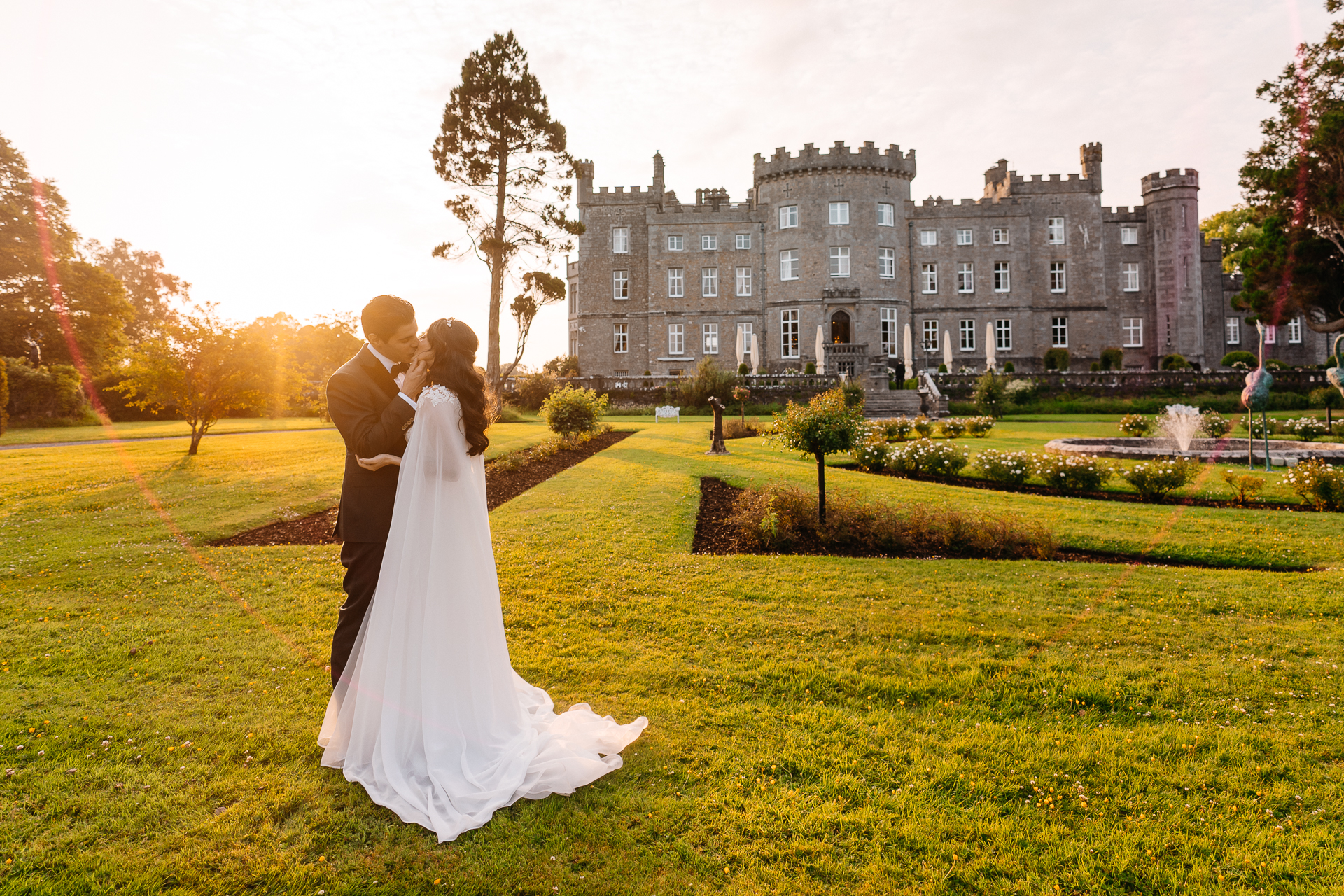 Bride and groom kissing in front of Markree Castle during golden hour


