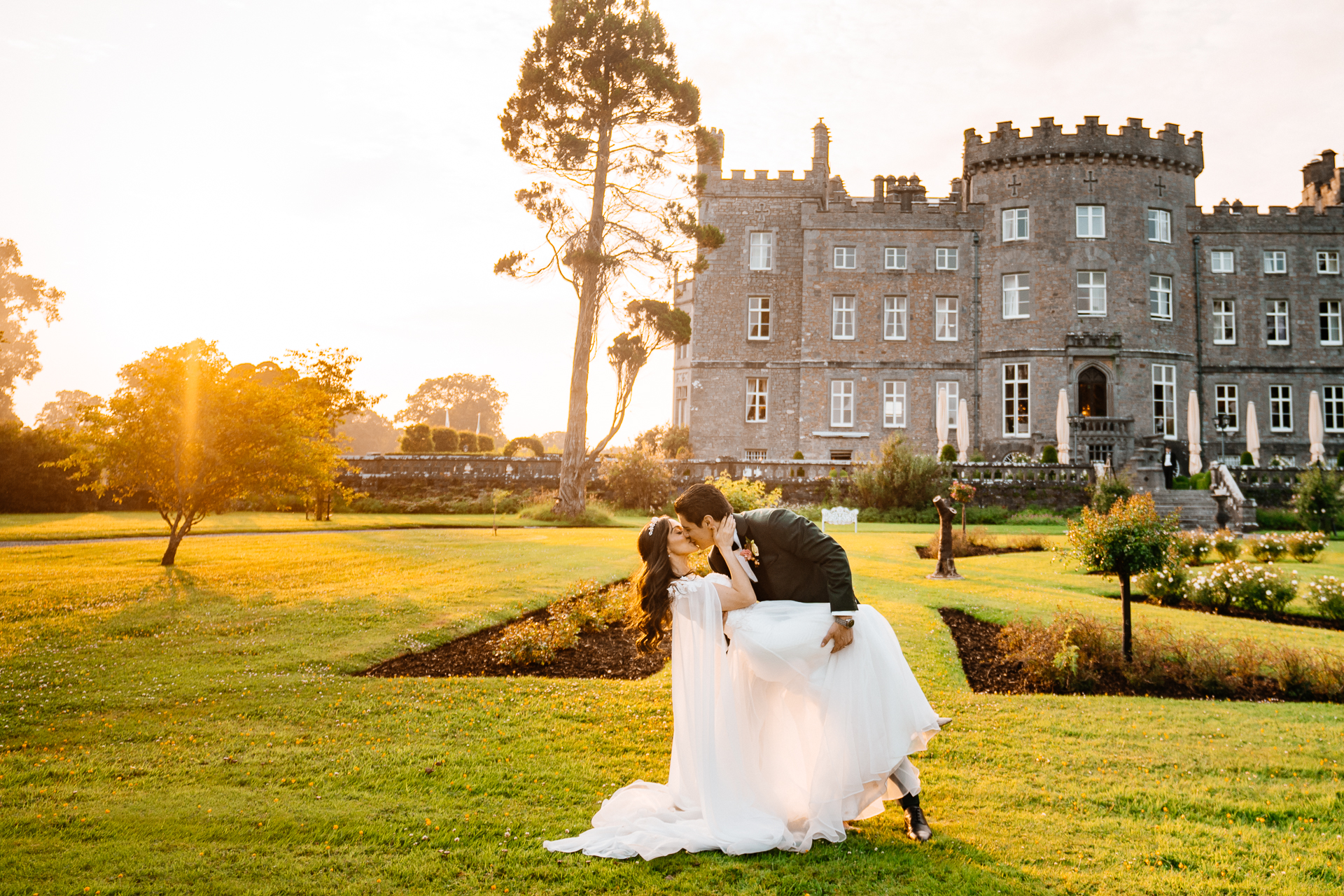 Bride and groom sharing a romantic lift in front of Markree Castle during golden hour

