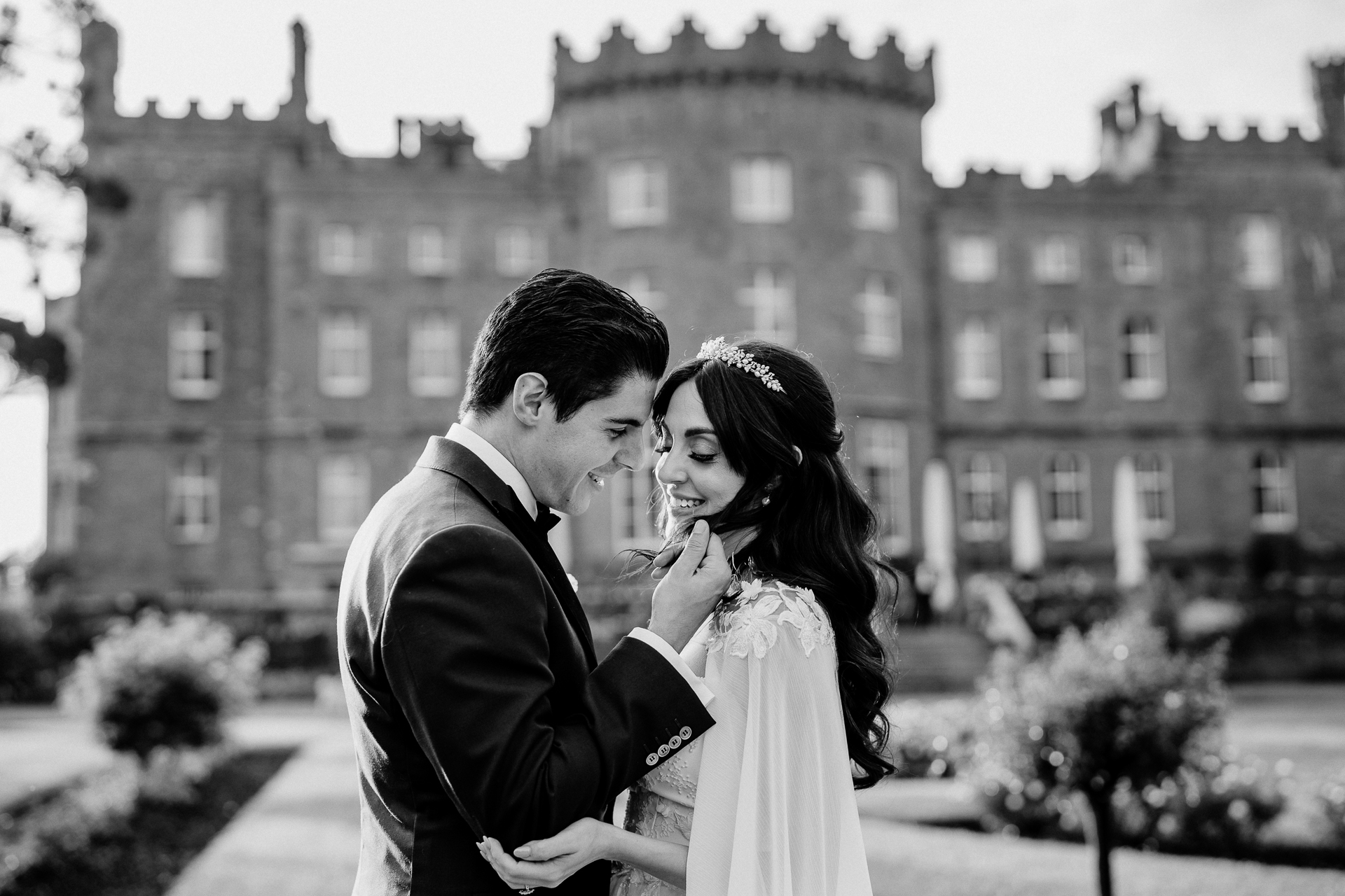 Bride and groom sharing a romantic kiss in front of Markree Castle – black and white photo


