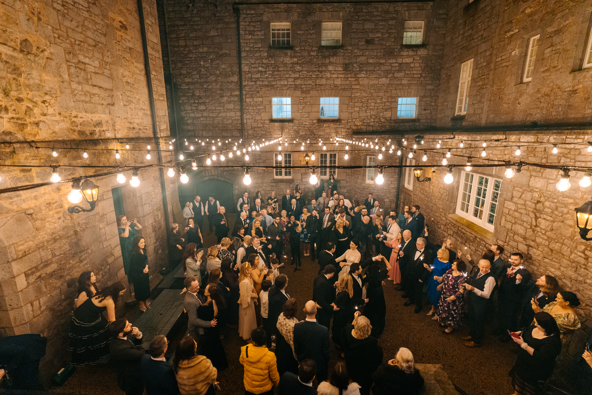 First dance in the Courtyard at Markree Castle surrounded by guests and string lights