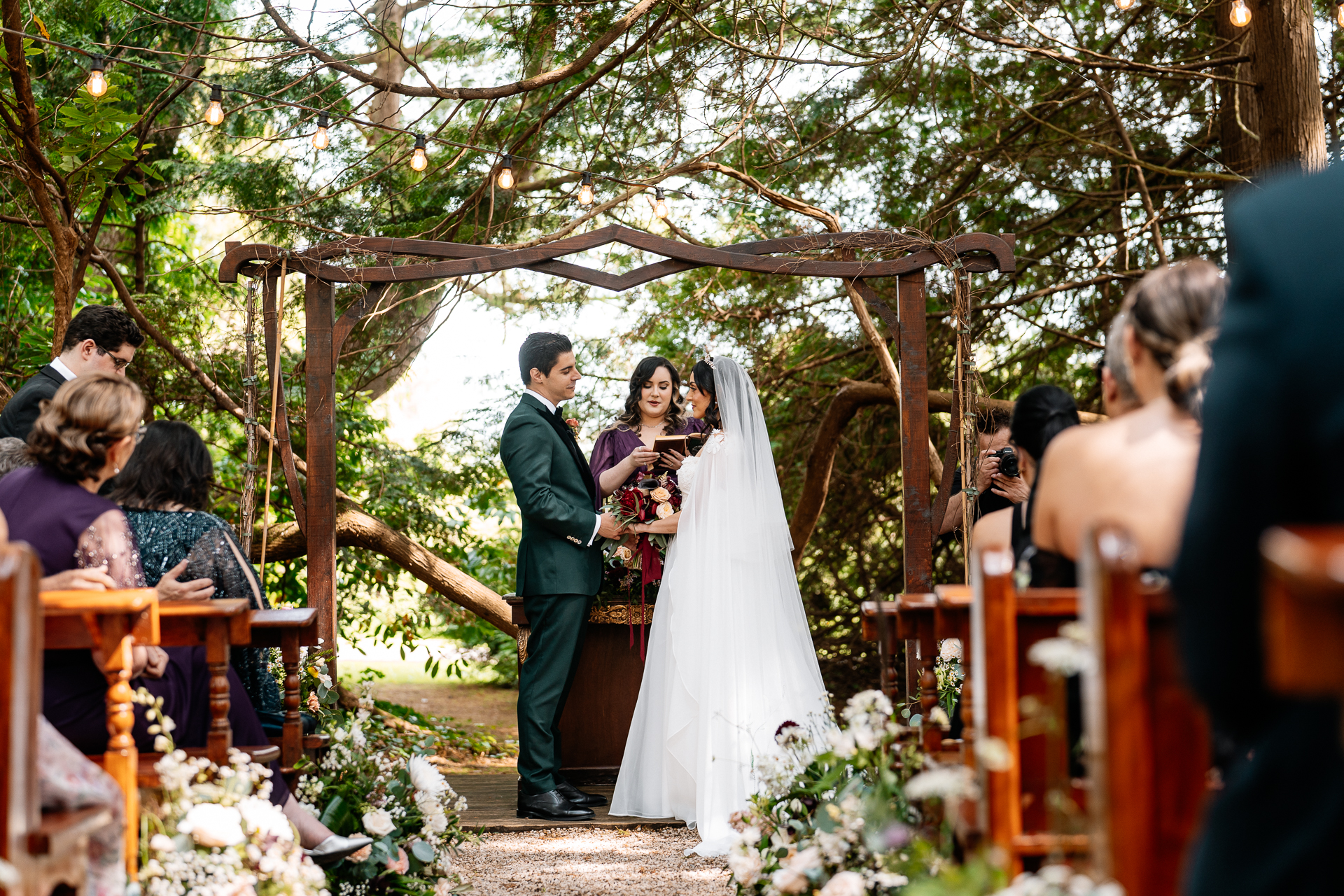 Bride and groom exchanging vows during a woodland ceremony in the forest clearing at Markree Castle