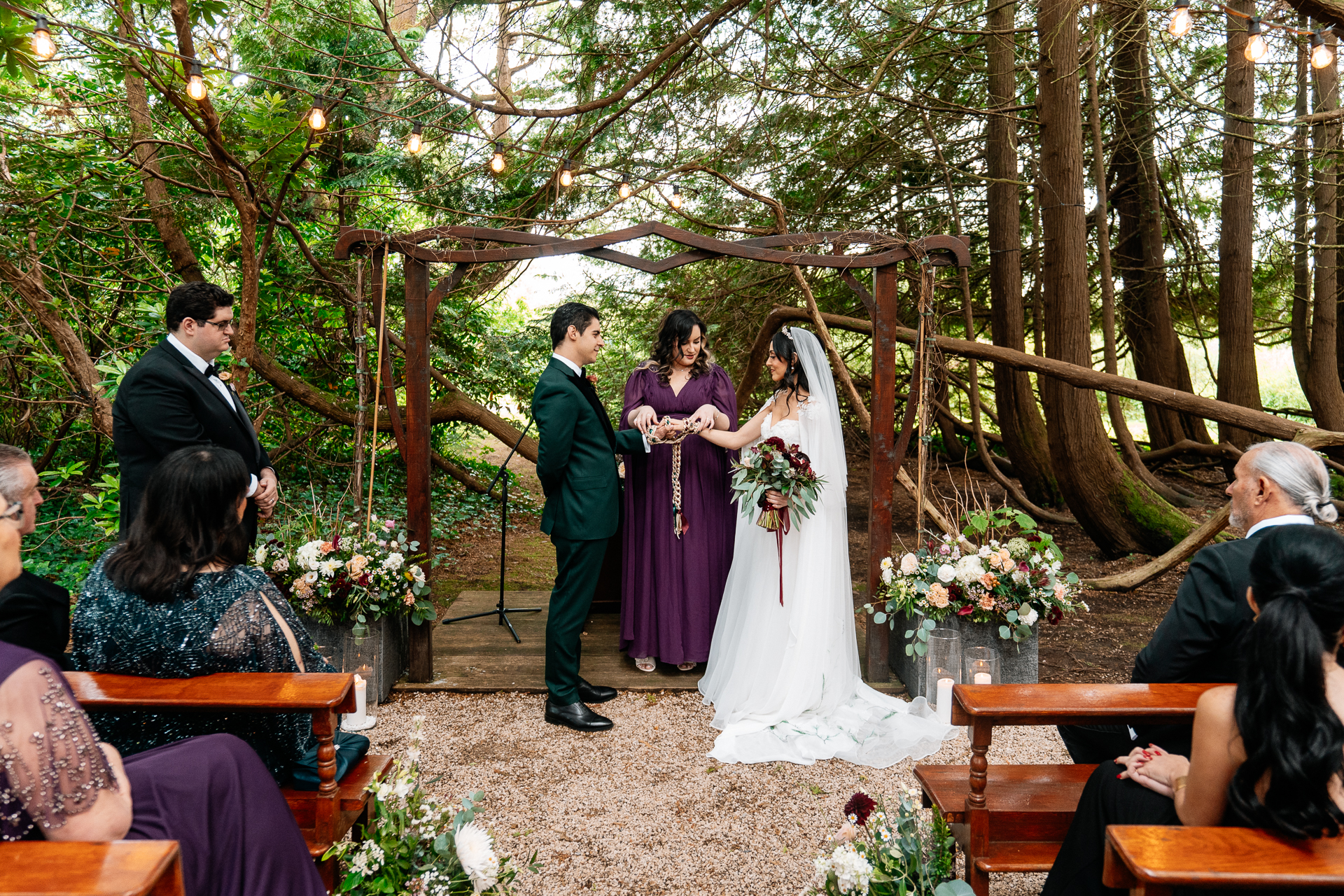 Bride and groom exchanging vows during a woodland ceremony in the forest clearing at Markree Castle