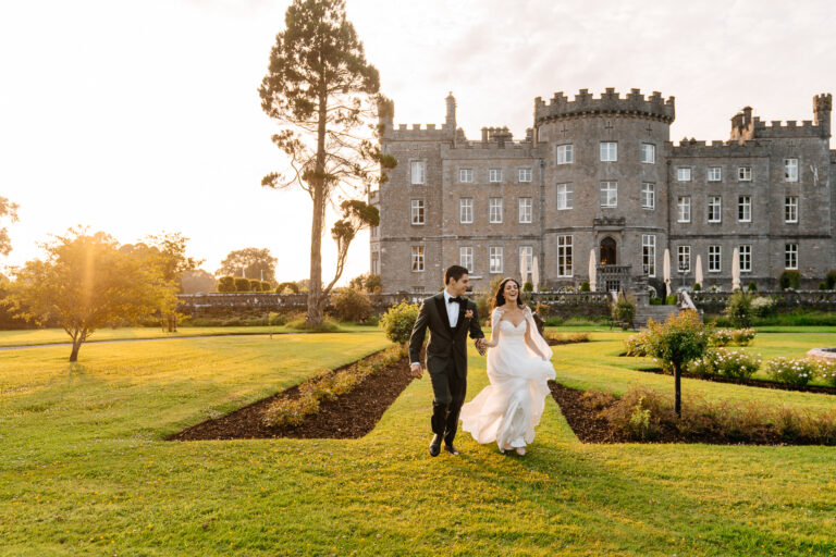 Bride and groom walking hand in hand in the sunset gardens of Markree Castle