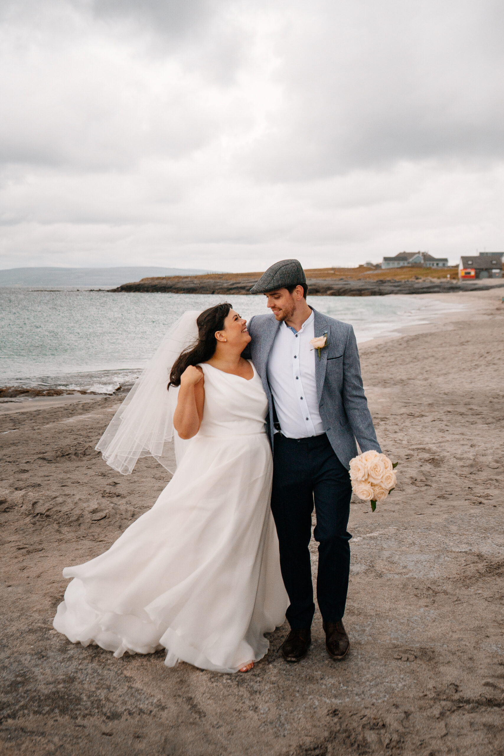 Bride and groom walking hand in hand along the beach on Inisheer – romantic wedding moment by the Atlantic shore