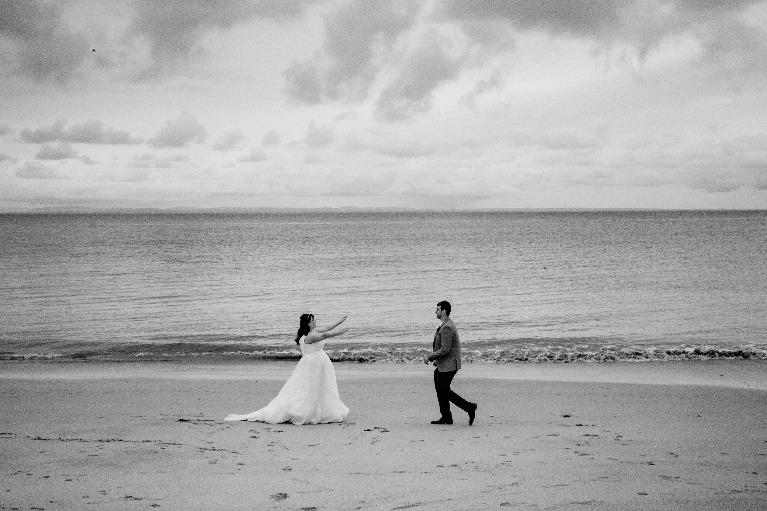 Bride and groom walking hand in hand on the beach of Inisheer – Aran Islands wedding in timeless black and white