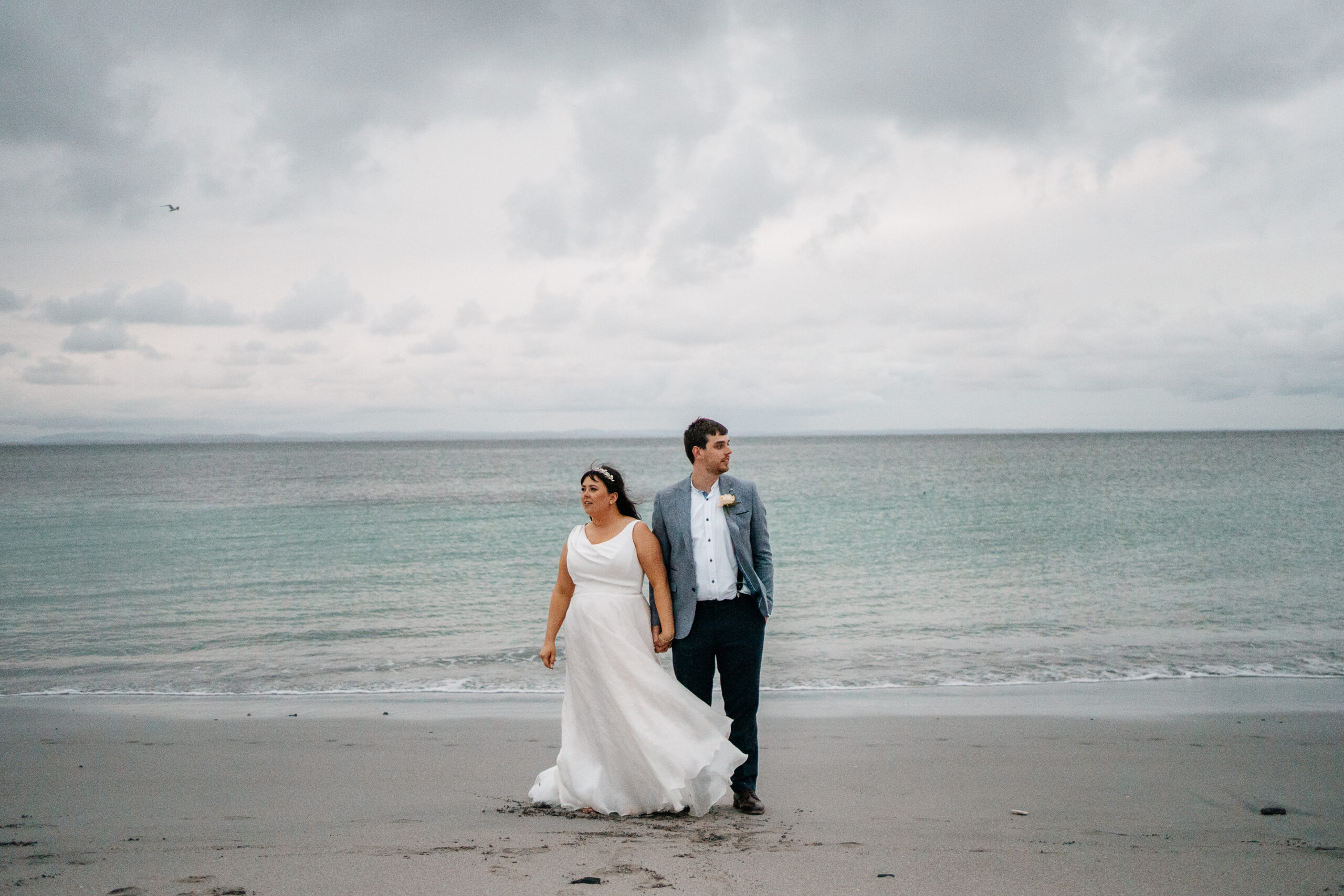 Bride and groom walking hand in hand on the beach of Inisheer – Aran Islands wedding in timeless black and white