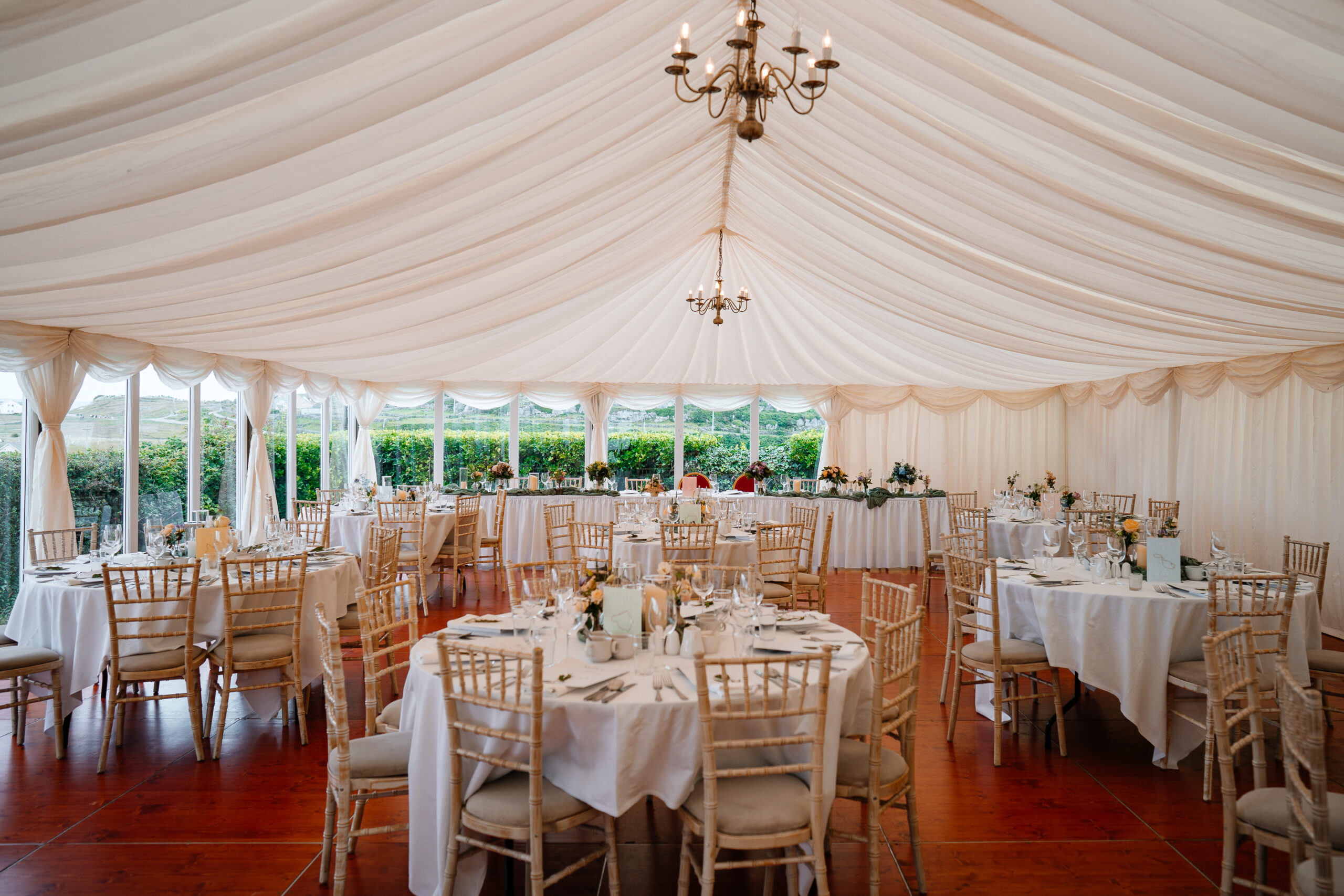 Elegant marquee wedding reception setup near Markree Castle with round tables and natural floral decor