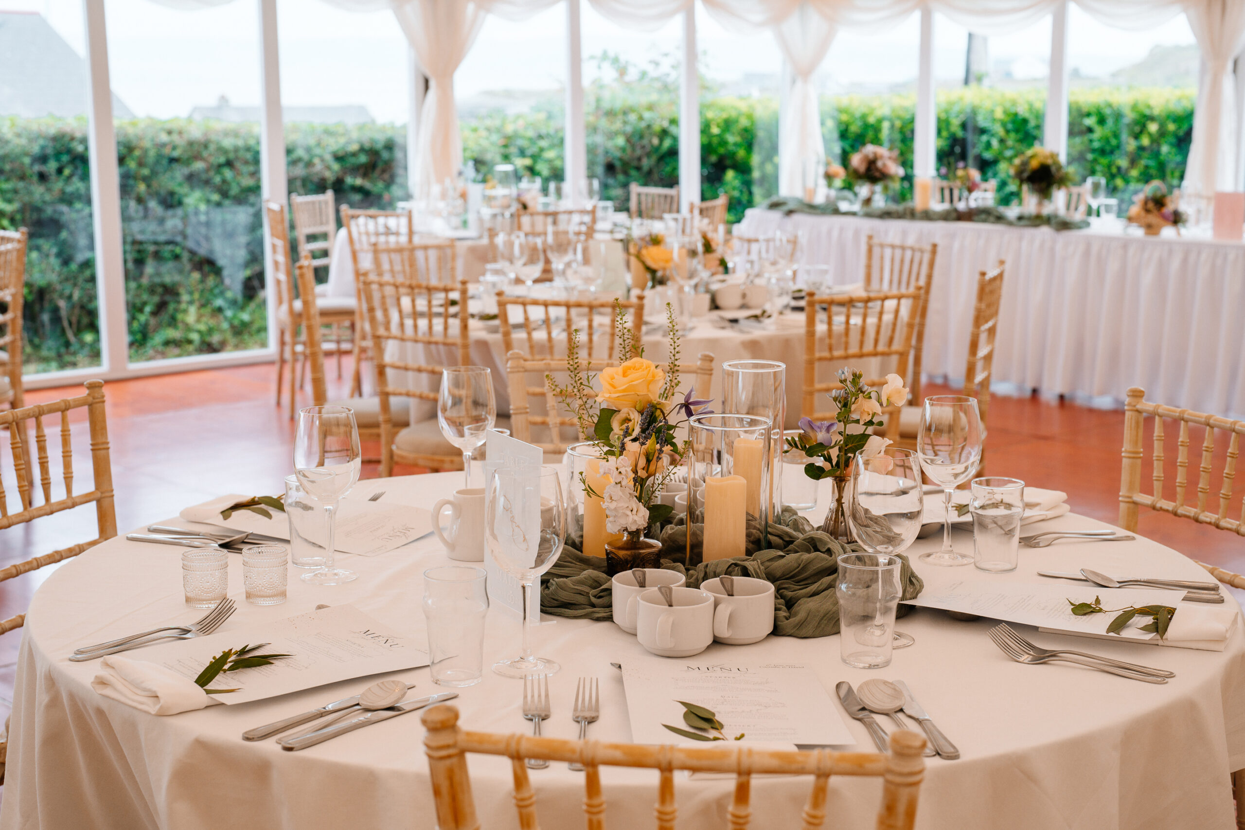 Elegant marquee wedding reception setup near Markree Castle with round tables and natural floral decor