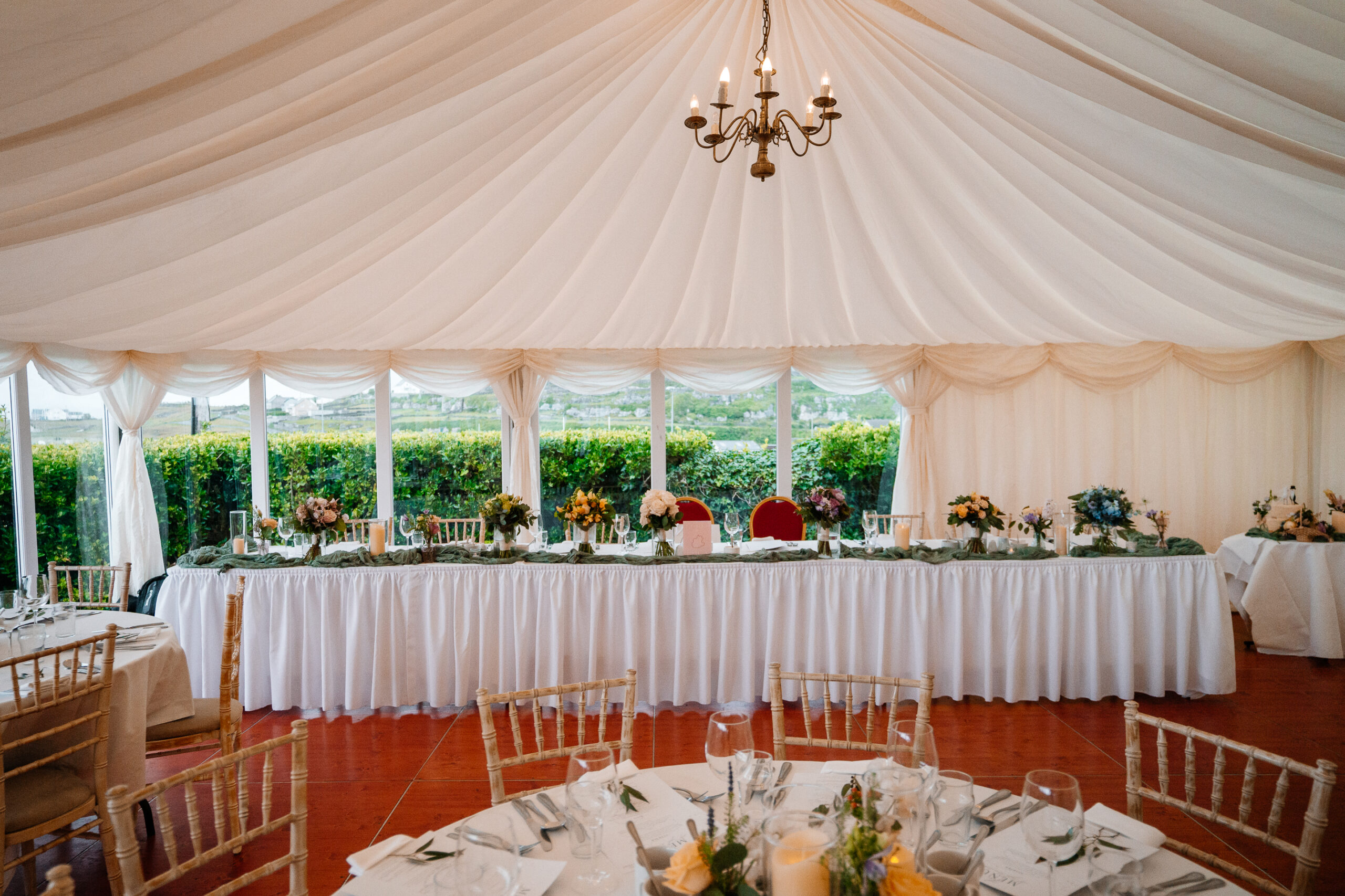 Elegant marquee wedding reception setup near Markree Castle with round tables and natural floral decor