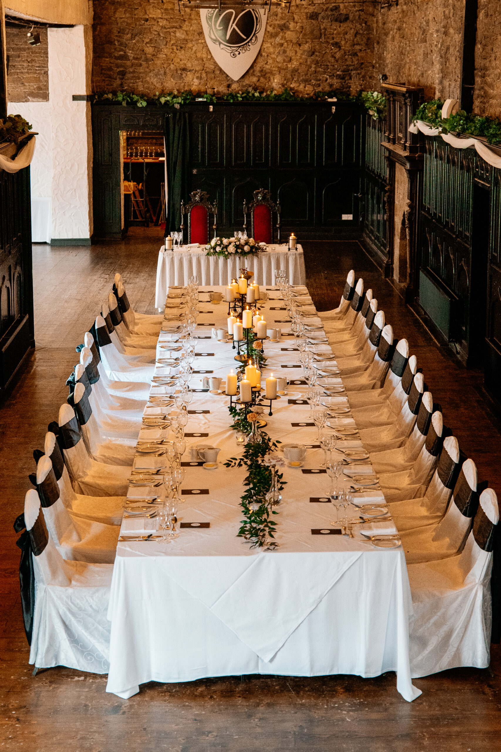 Cozy dining room and library bar setup at Kinnity Castle Hotel with bookshelves, open fire, rustic florals, and elegant details.