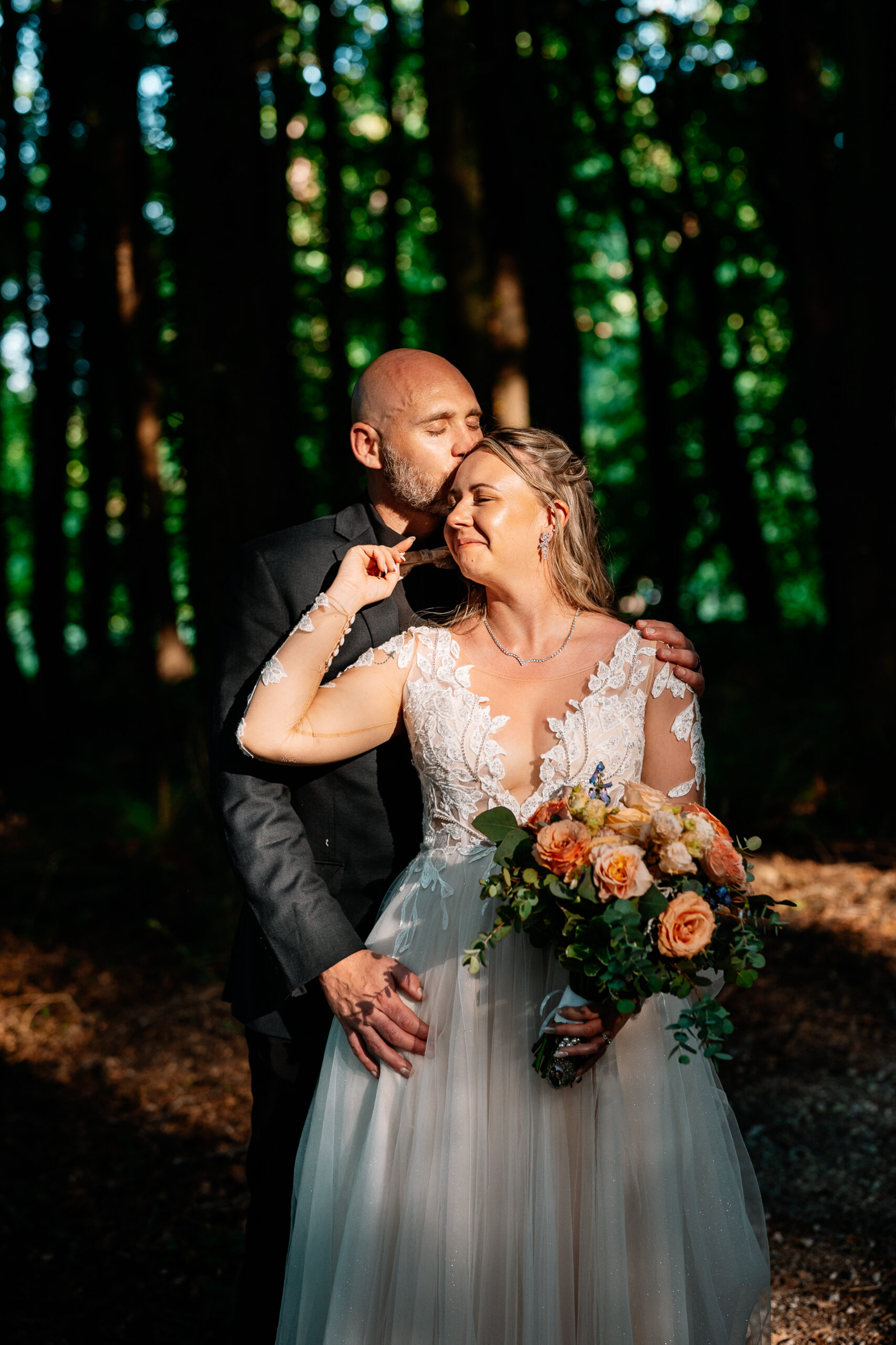 Bride and groom walking across Kinnitty Suspension Bridge and forest paths at sunset near Kinnitty Castle Hotel.