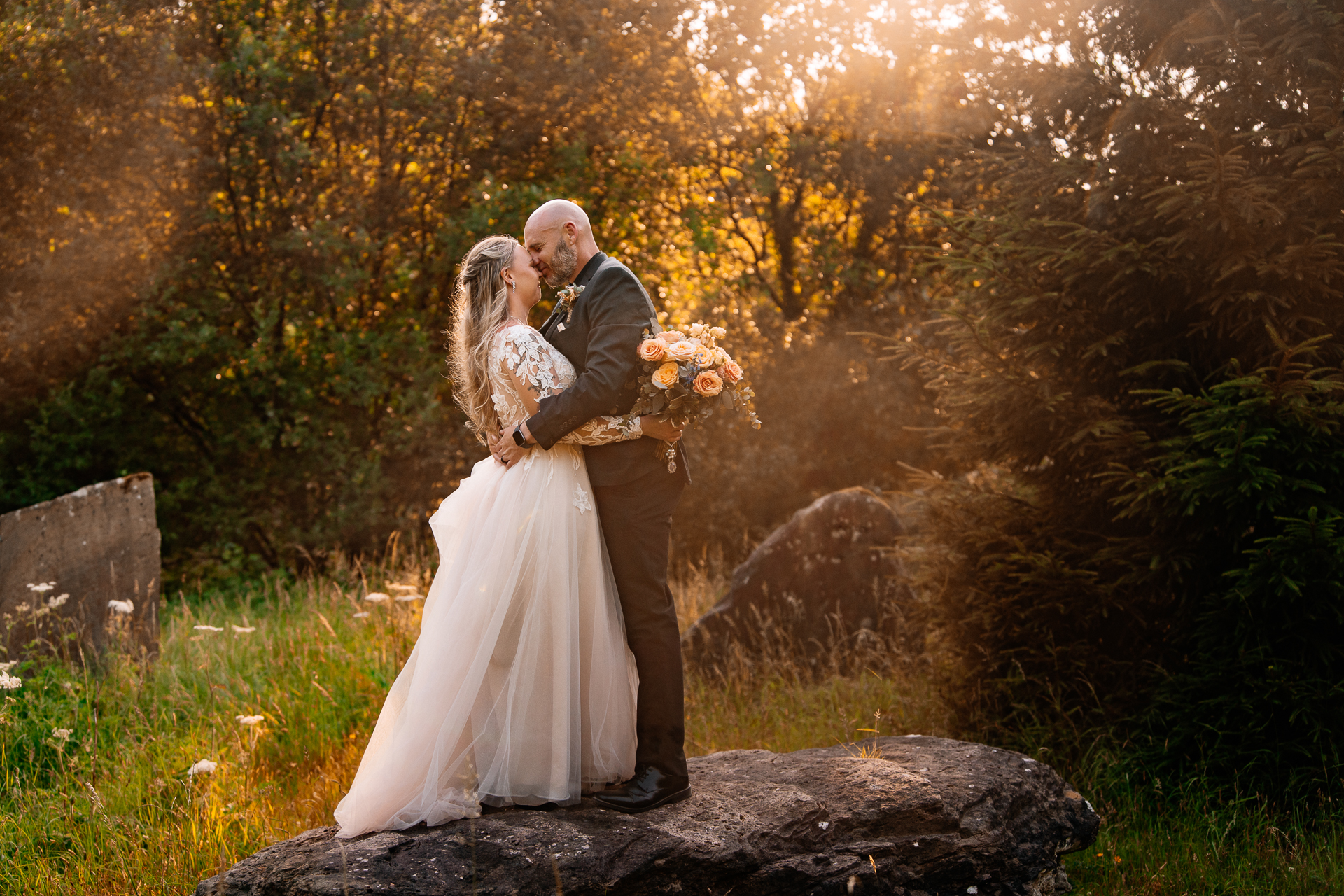 Bride and groom walking across Kinnitty Suspension Bridge and forest paths at sunset near Kinnitty Castle Hotel.