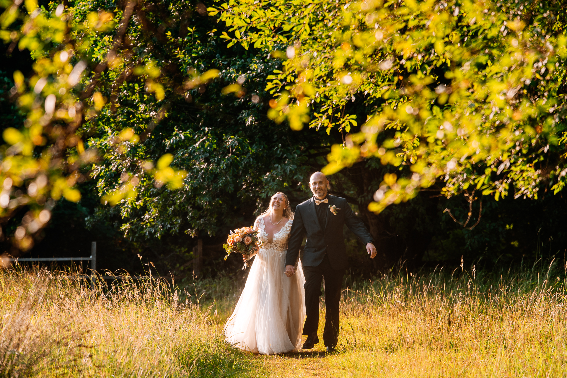 Bride and groom walking across Kinnitty Suspension Bridge and forest paths at sunset near Kinnitty Castle Hotel.