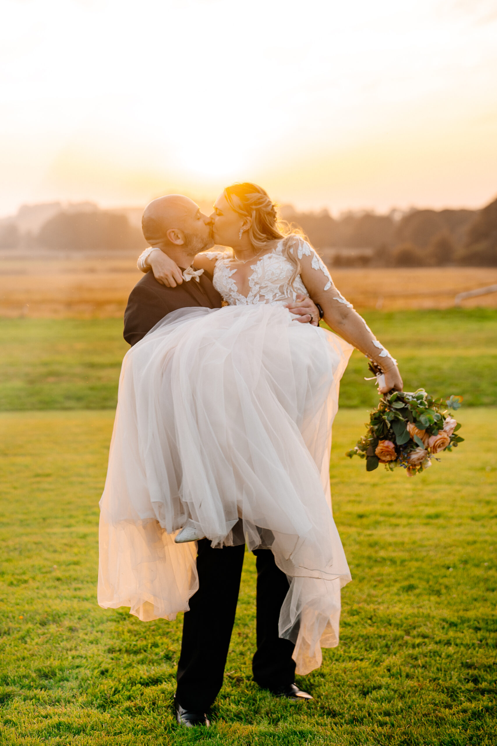Groom carrying bride at sunset across the lawn – Kinnitty Castle Hotel wedding