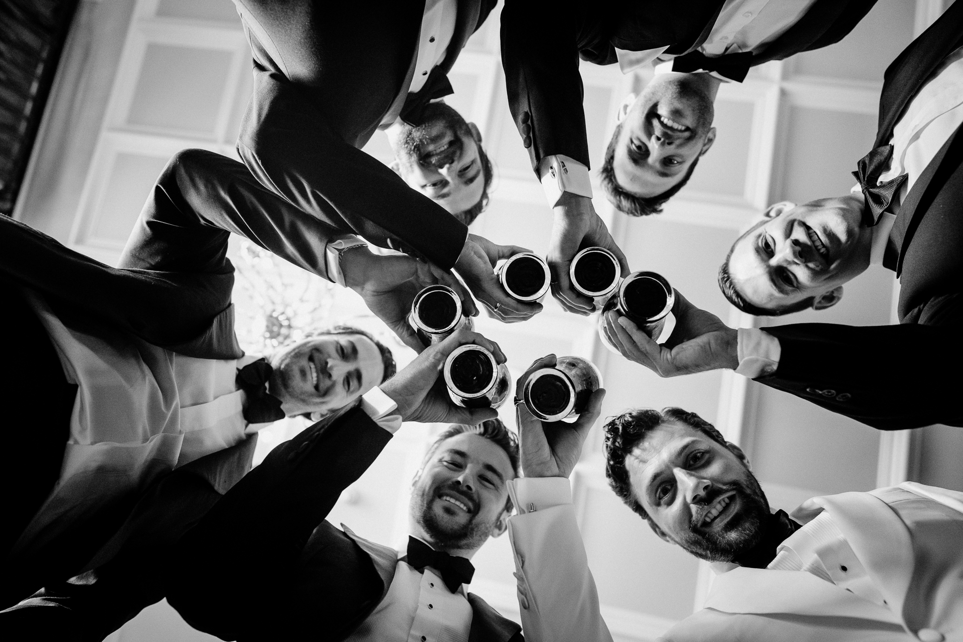 Groom and groomsmen toasting with beers in a fun black and white wedding photo at Markree Castle

