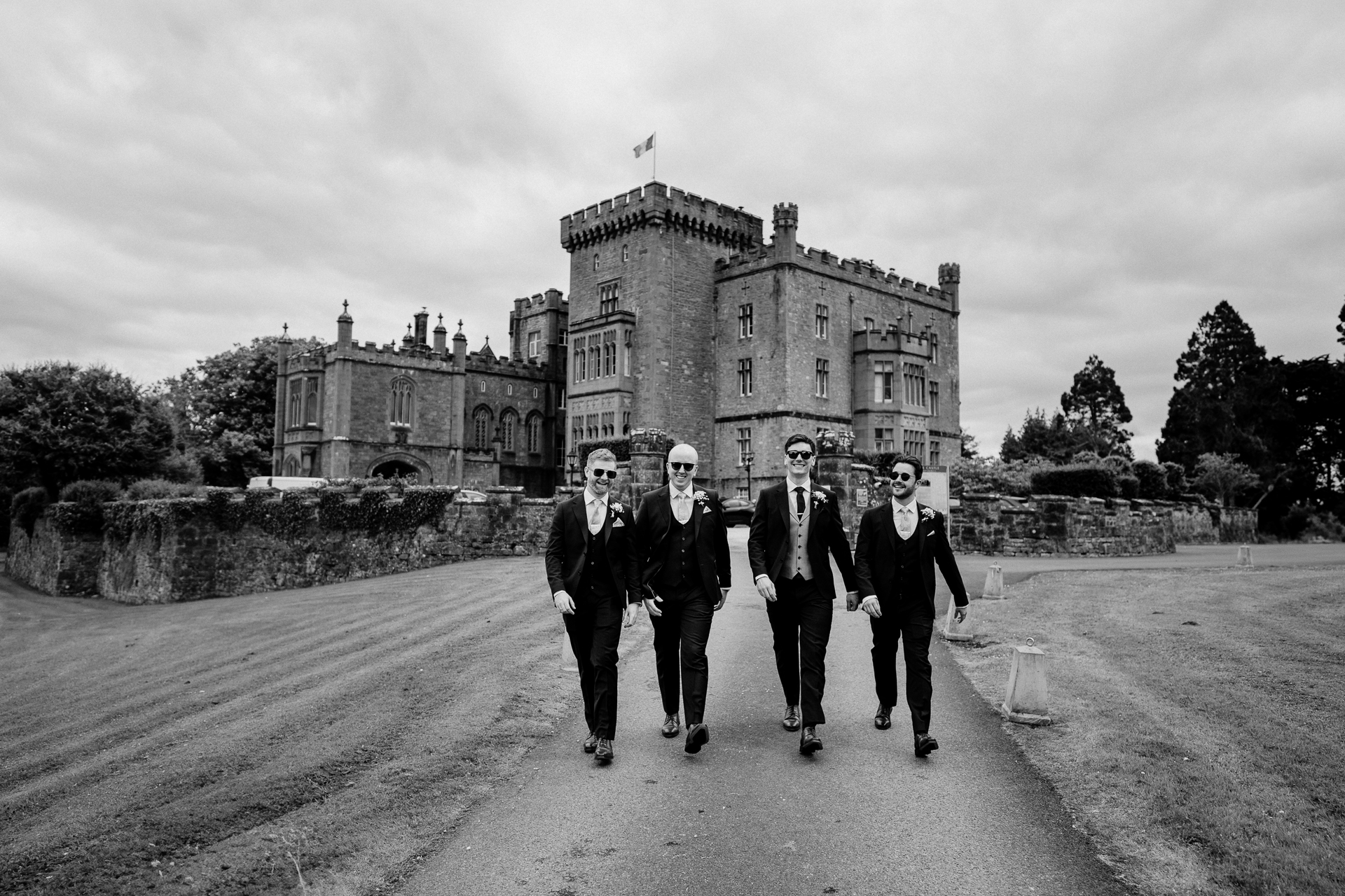 Groomsmen walking in front of Markree Castle – black and white wedding photo

