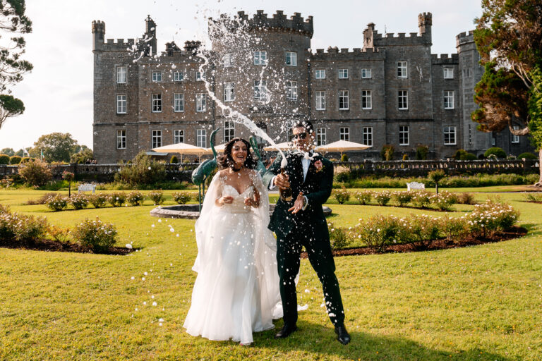 Bride and groom popping champagne in the garden at Markree Castle wedding