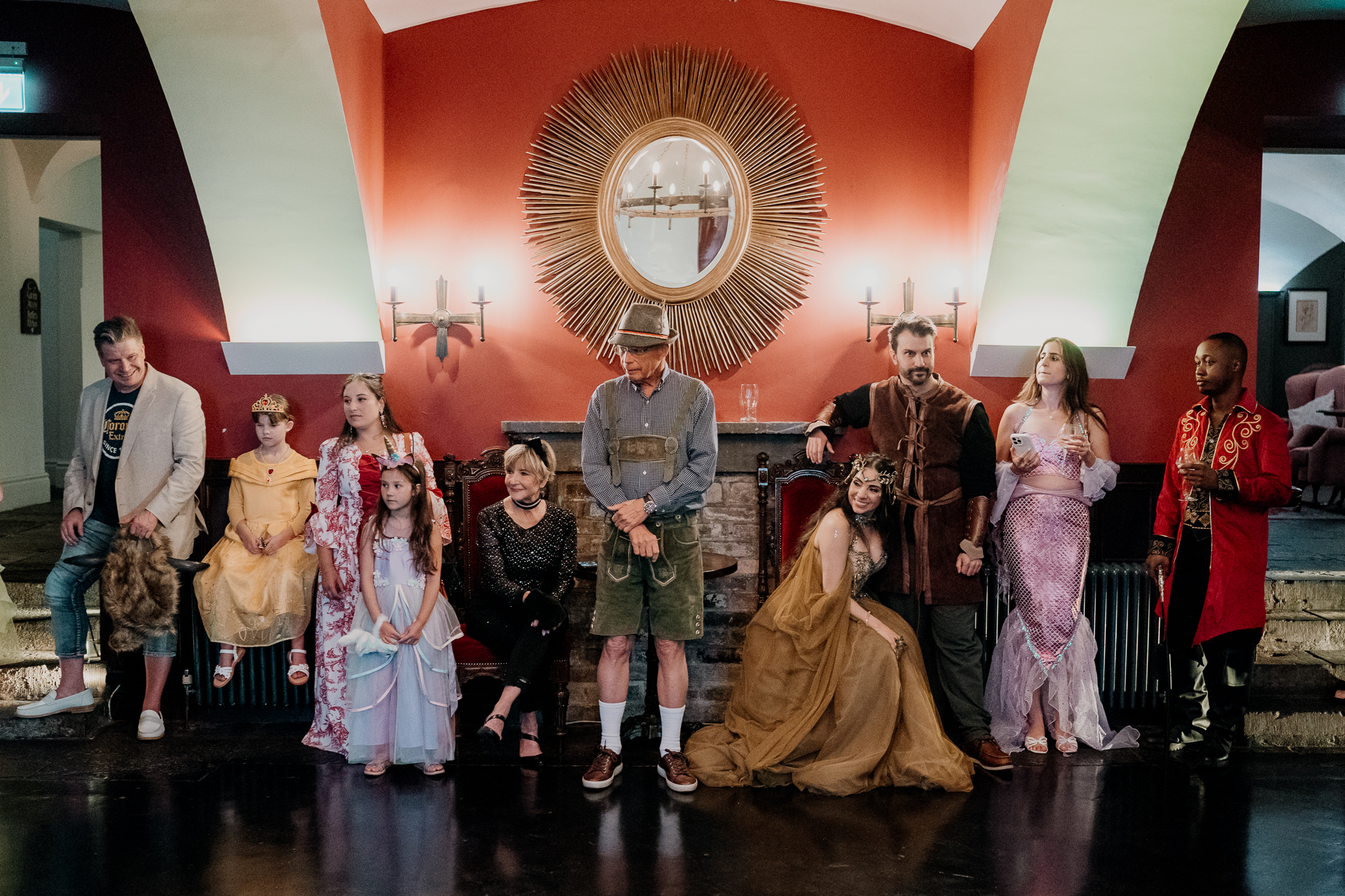 Group of guests in fantasy-inspired costumes posing for a photo during a rehearsal dinner at Markree Castle, Sligo, Ireland