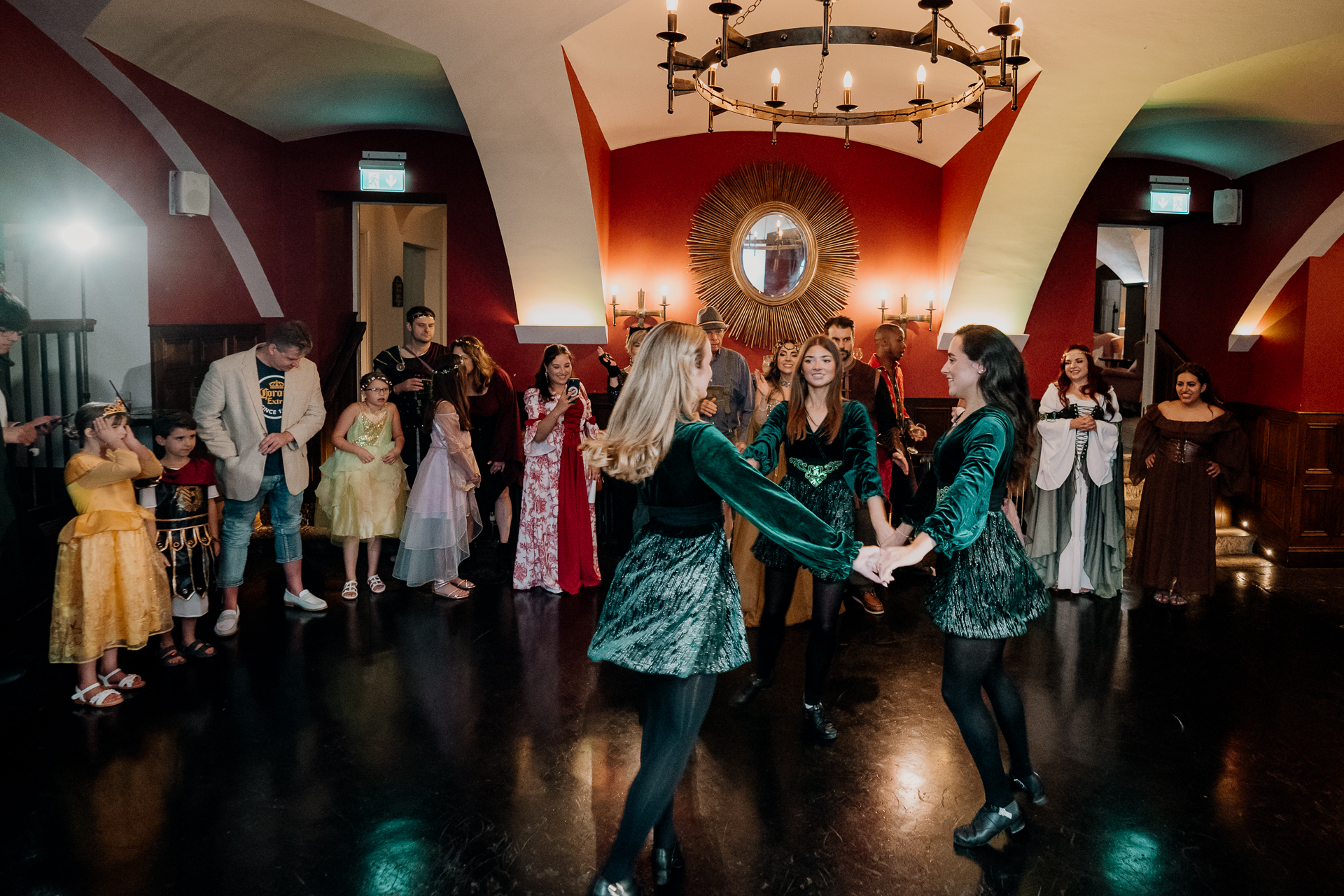 Group of guests in fantasy-inspired costumes posing for a photo during a rehearsal dinner at Markree Castle, Sligo, Ireland