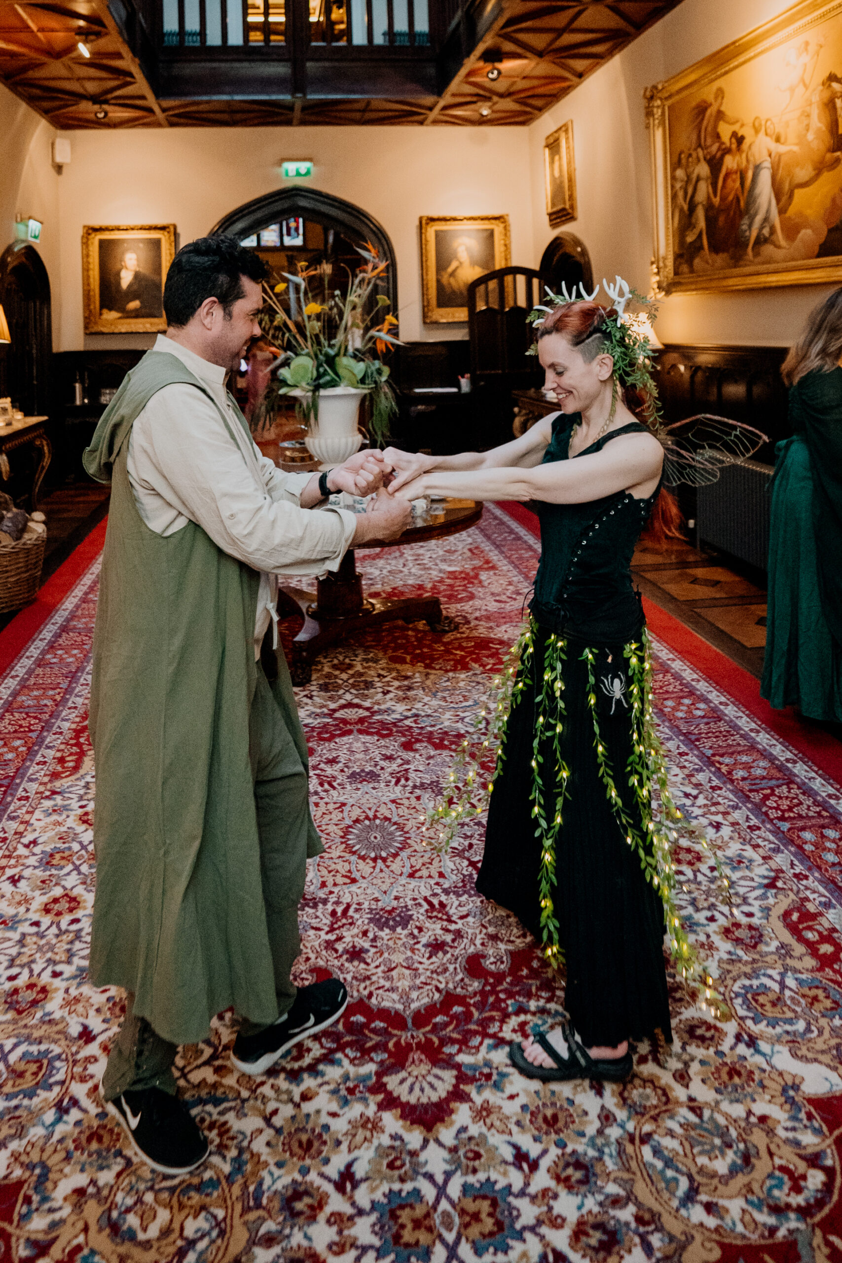 Couple in medieval fantasy costumes posing in the grand hall of Markree Castle during a themed rehearsal dinner in Sligo, Ireland