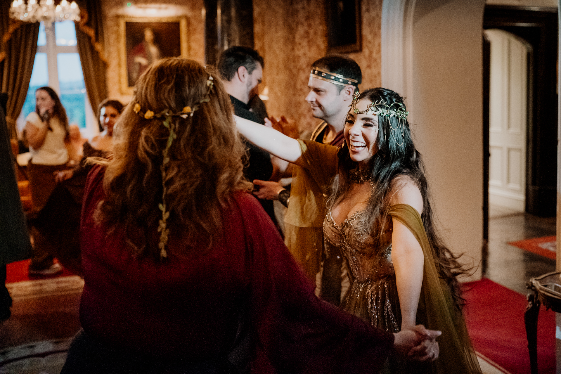Bride and groom in fantasy-inspired costumes walking hand in hand during rehearsal dinner at Markree Castle, Sligo, Ireland