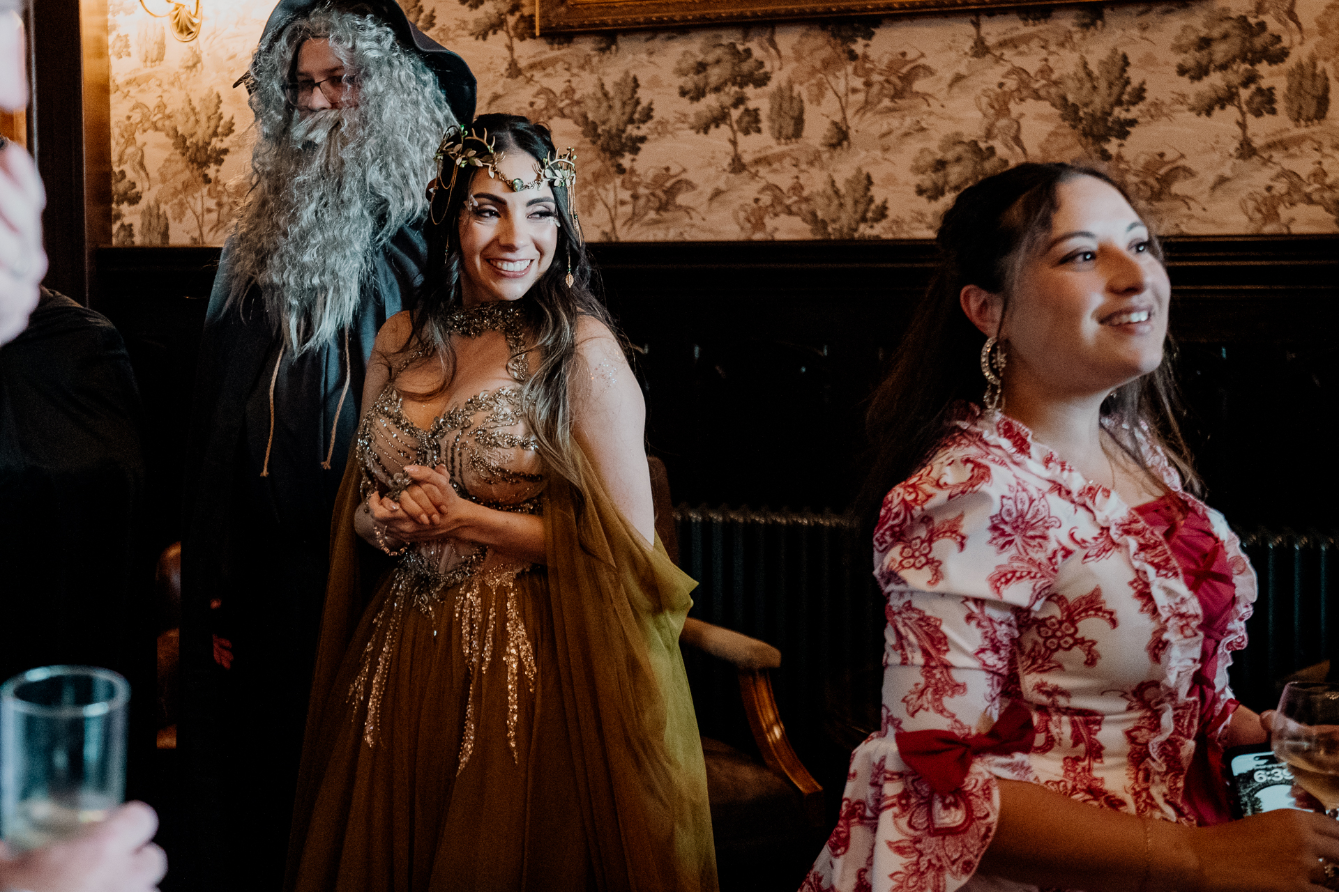 Wedding guests in elaborate fantasy costumes pose in the grand hall of Markree Castle during a rehearsal dinner in Sligo, Ireland