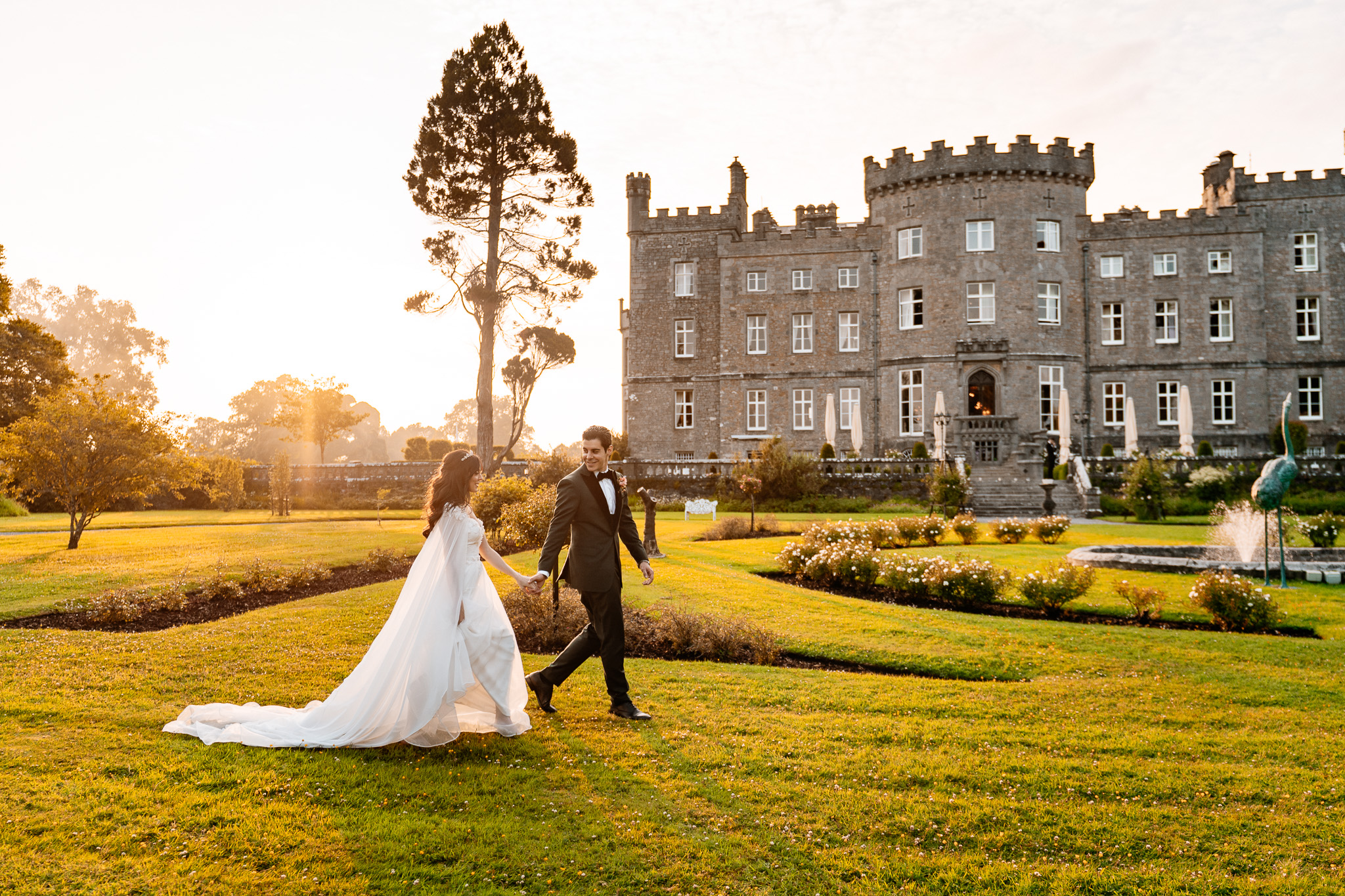 Newlyweds photographed in the gardens at sunset with Markree Castle behind them