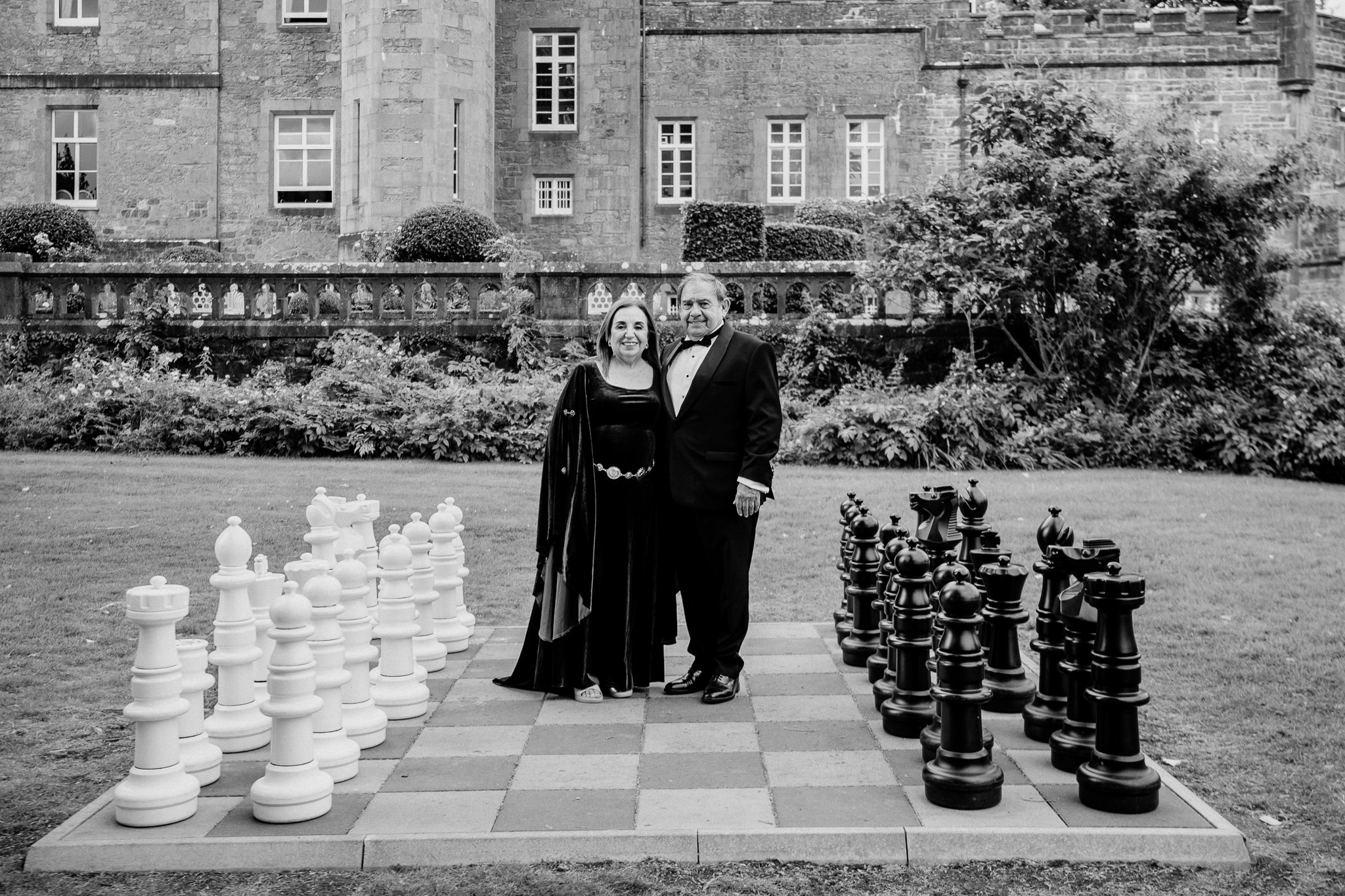 Black and white portrait of wedding guests beside the giant chess set at Markree Castle