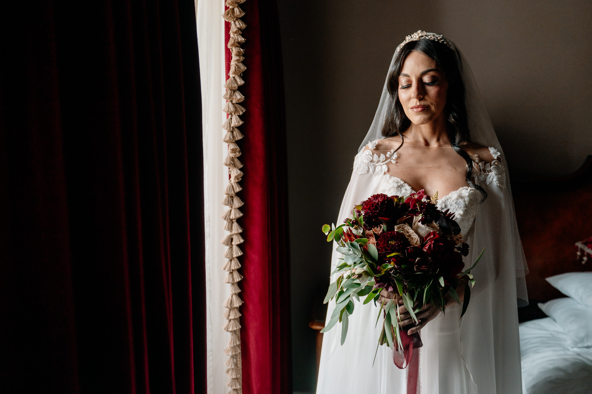 Bride holding her wedding bouquet by the window at Markree Castle