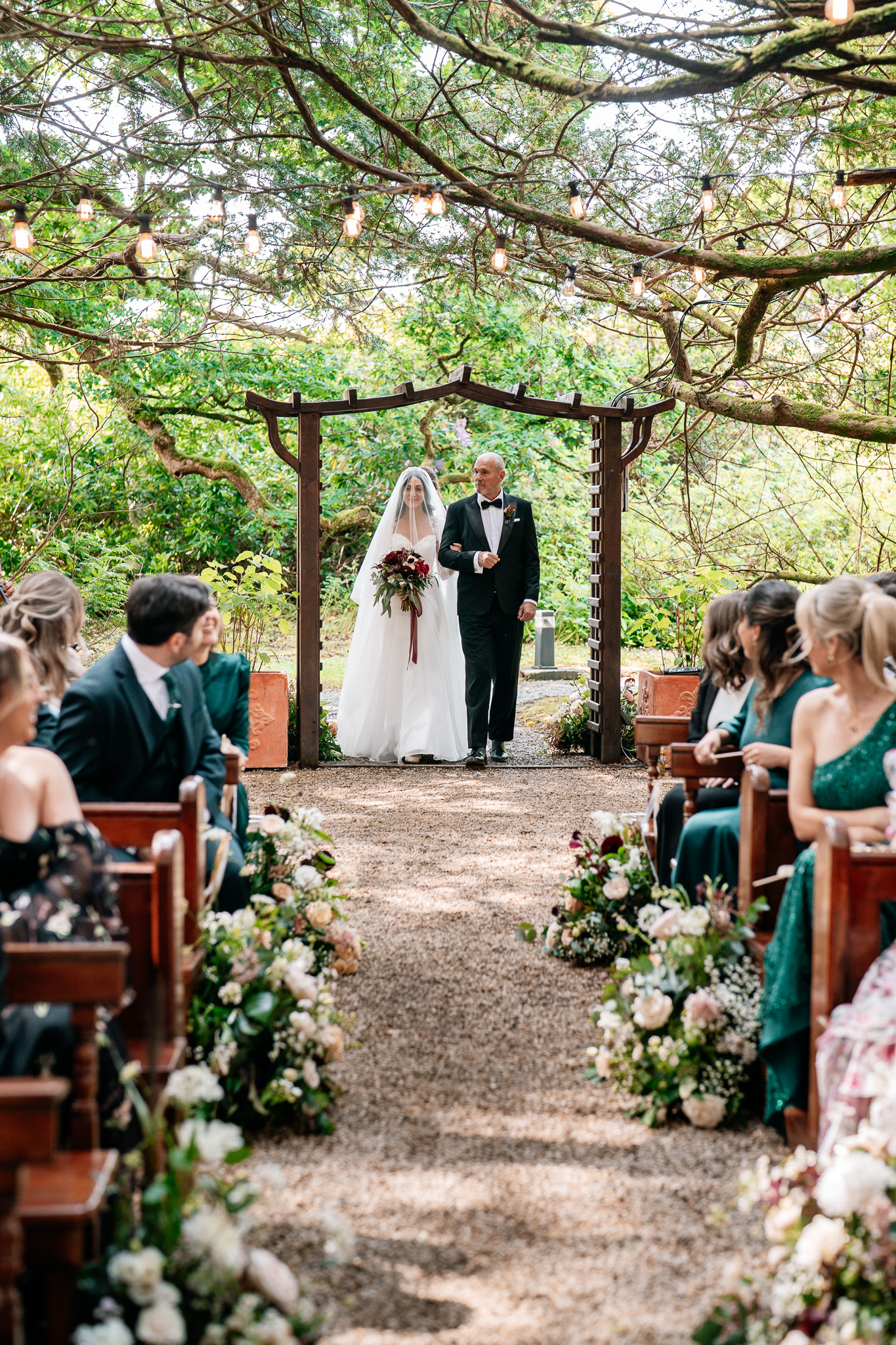 Bride walking down the aisle with her father at a Markree Castle woodland wedding