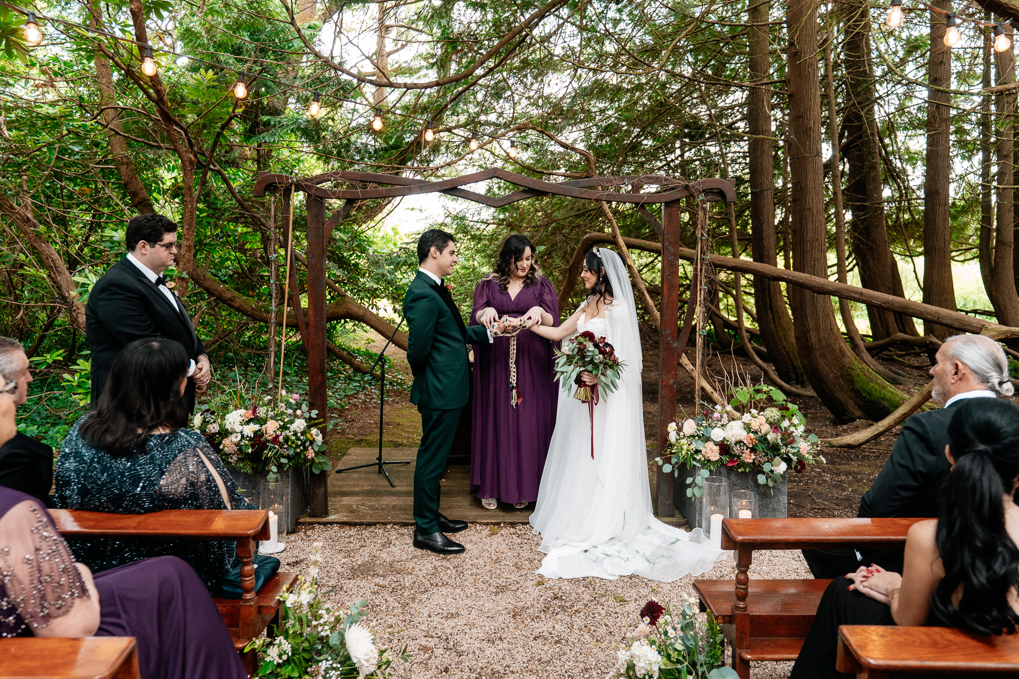 Bride and groom with their celebrant during a Markree Castle woodland wedding